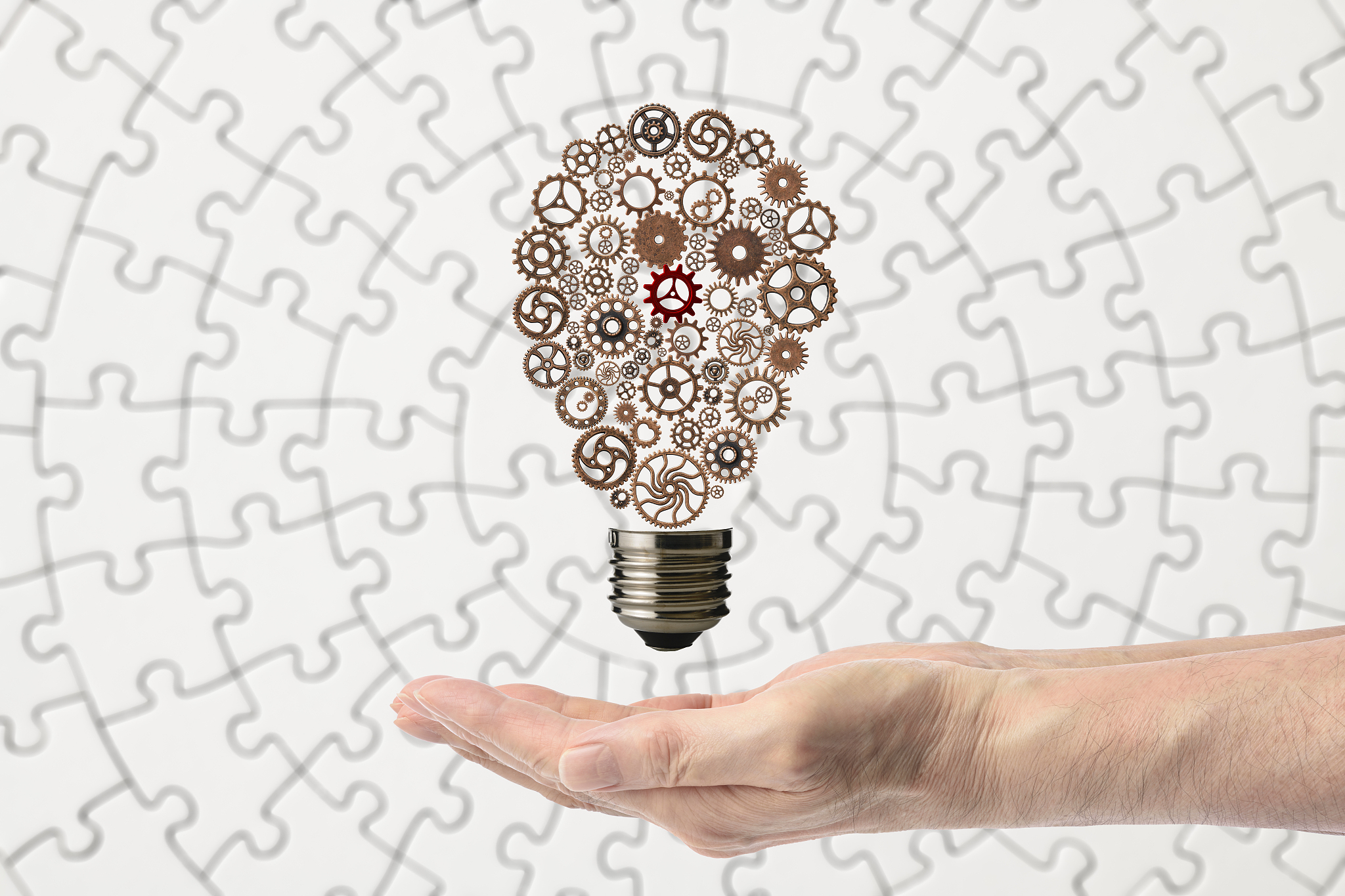 light bulb with metal gears floating on the hand