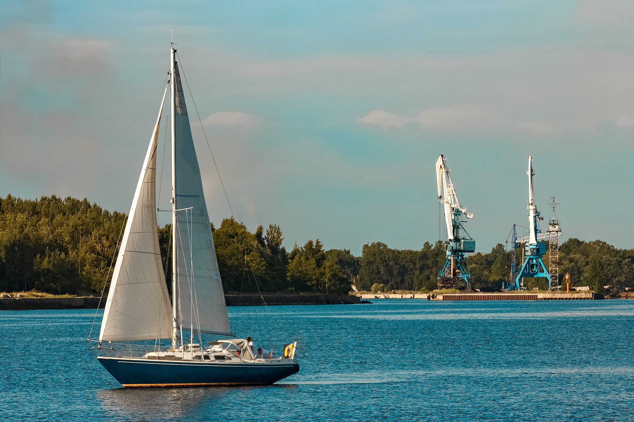 blue sailboat at river