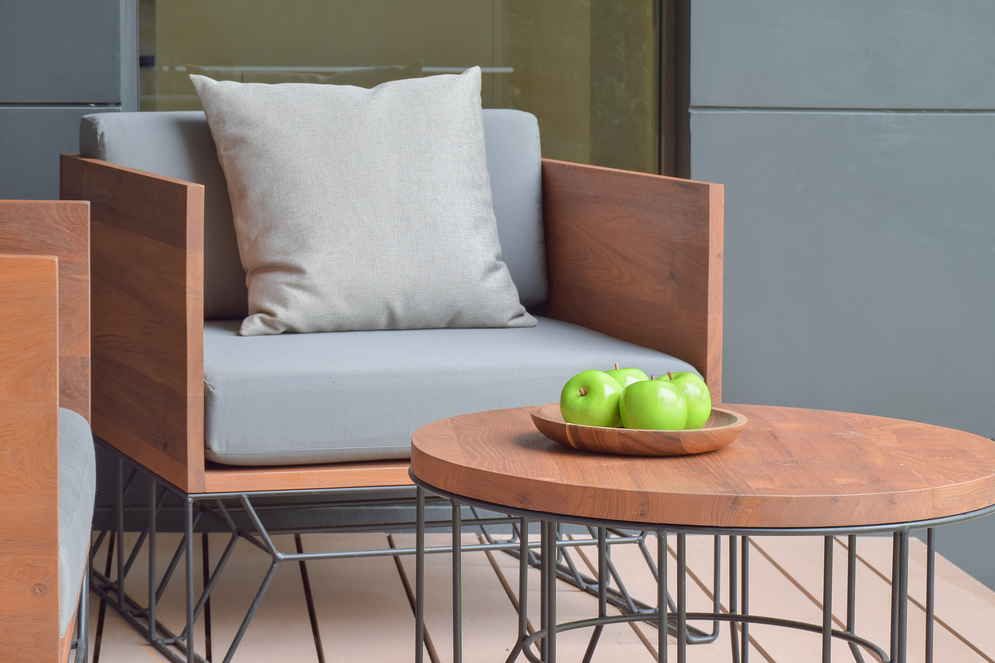 apple tray on wooden top table next to outdoor cushion