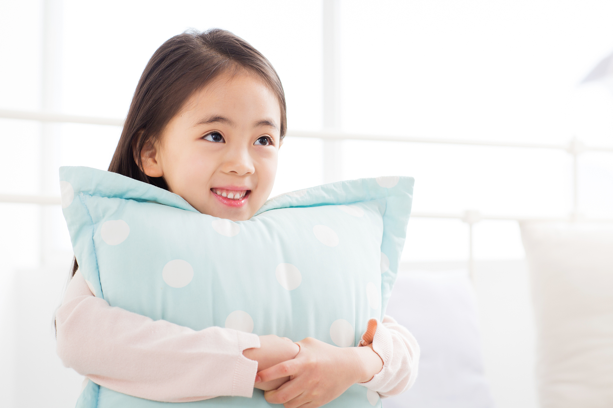 a girl embracing a cushion
