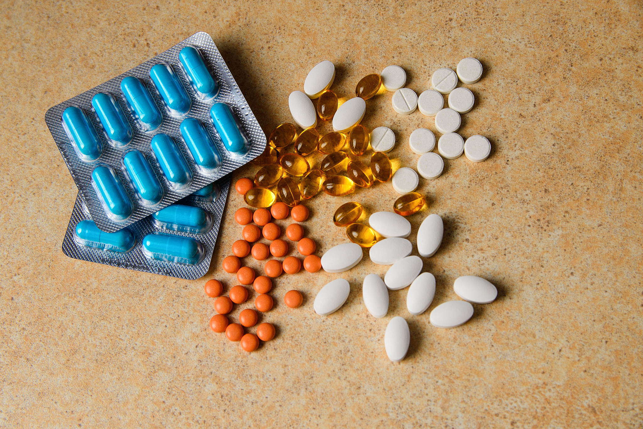 blister with blue, pink and orange pills, vitamin d and fish oil