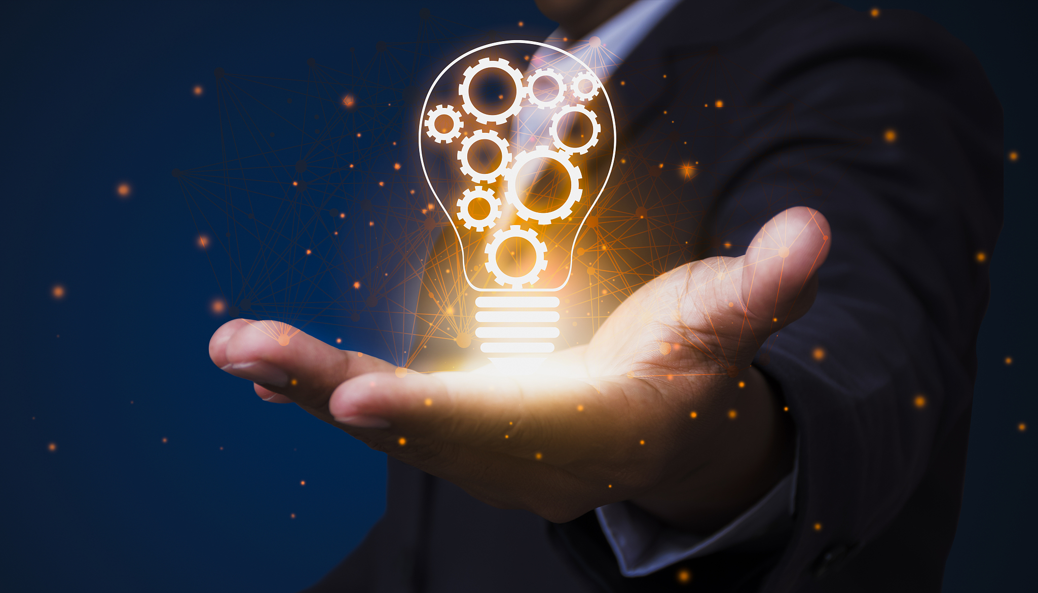a businessman who holds a light bulb with an internal gear demon