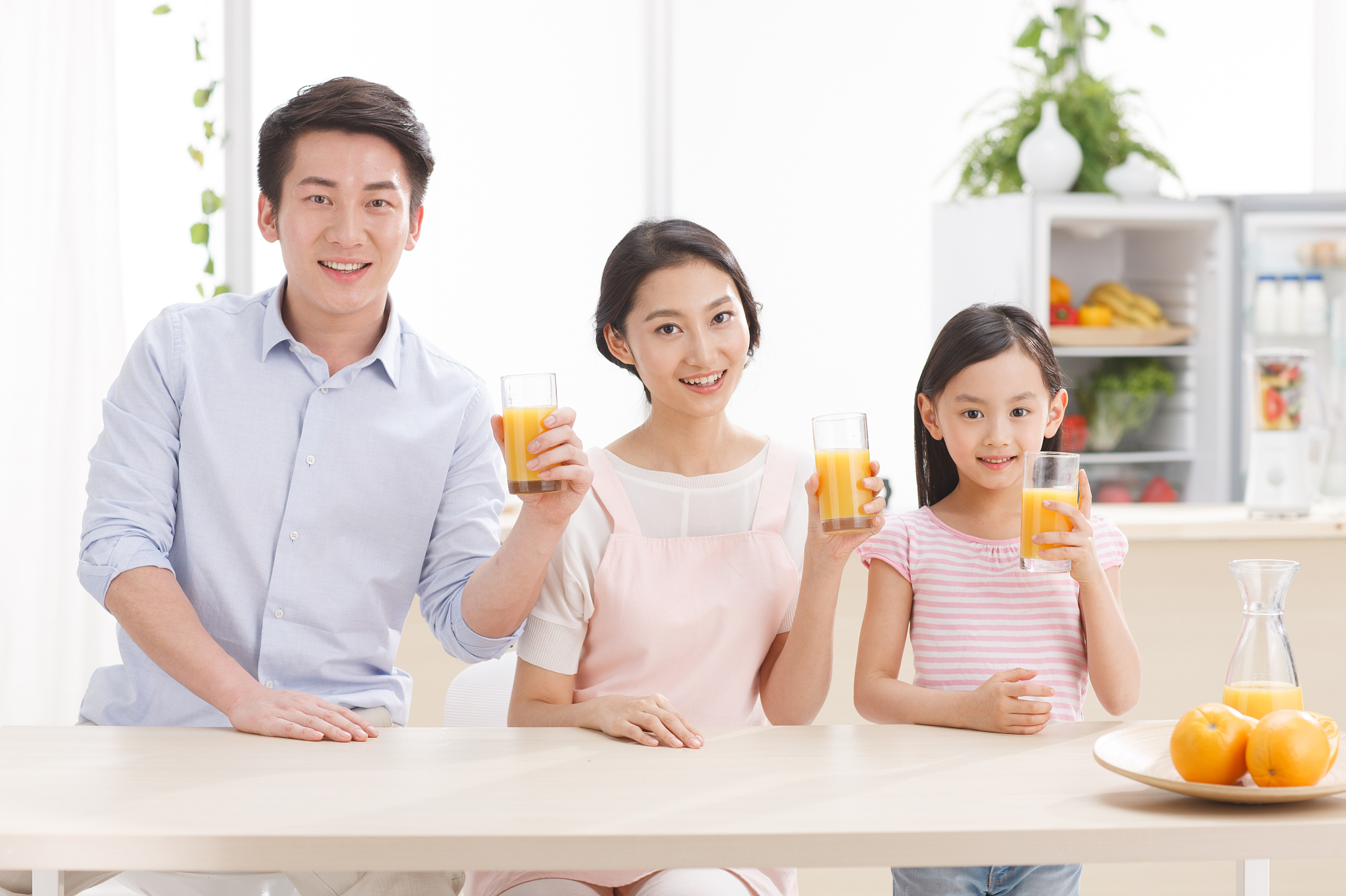 幸福的一家三口在喝果汁