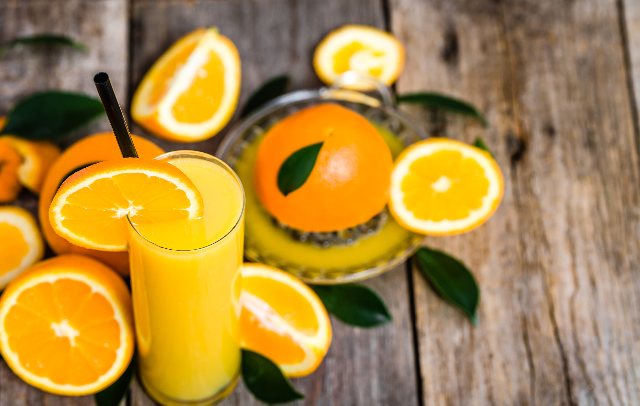 glass of orange juice and fresh orange fruits on wood
