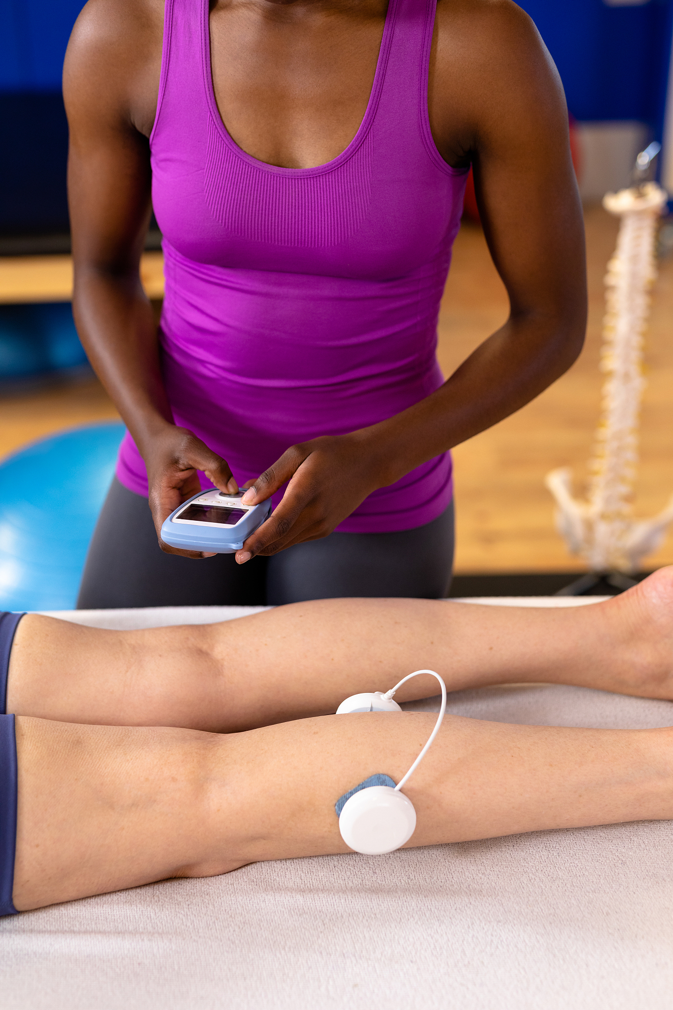 physiotherapist giving electro stimulation to active senior woma