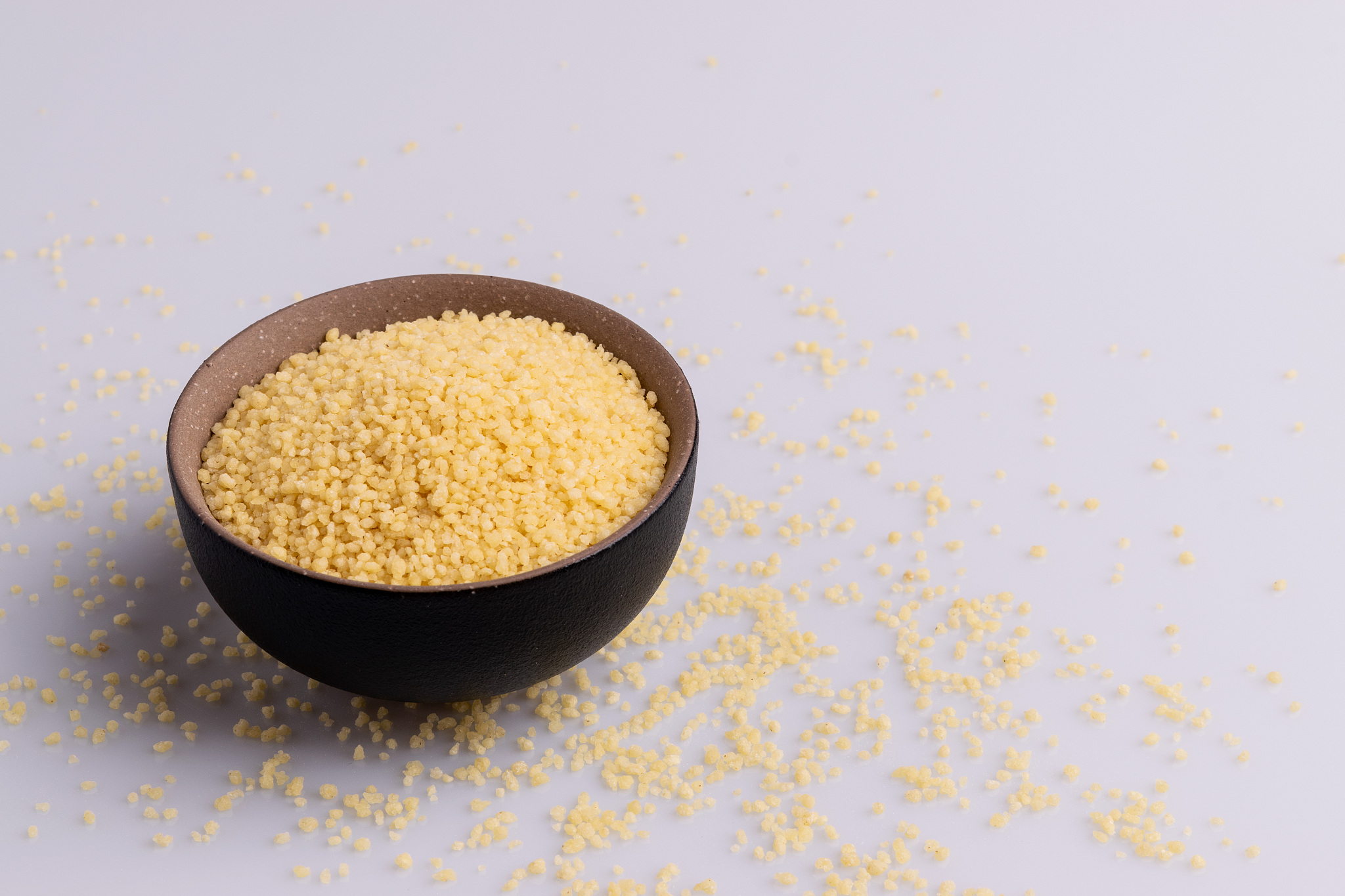 dry couscous isolated on white background, soft light, copy spac