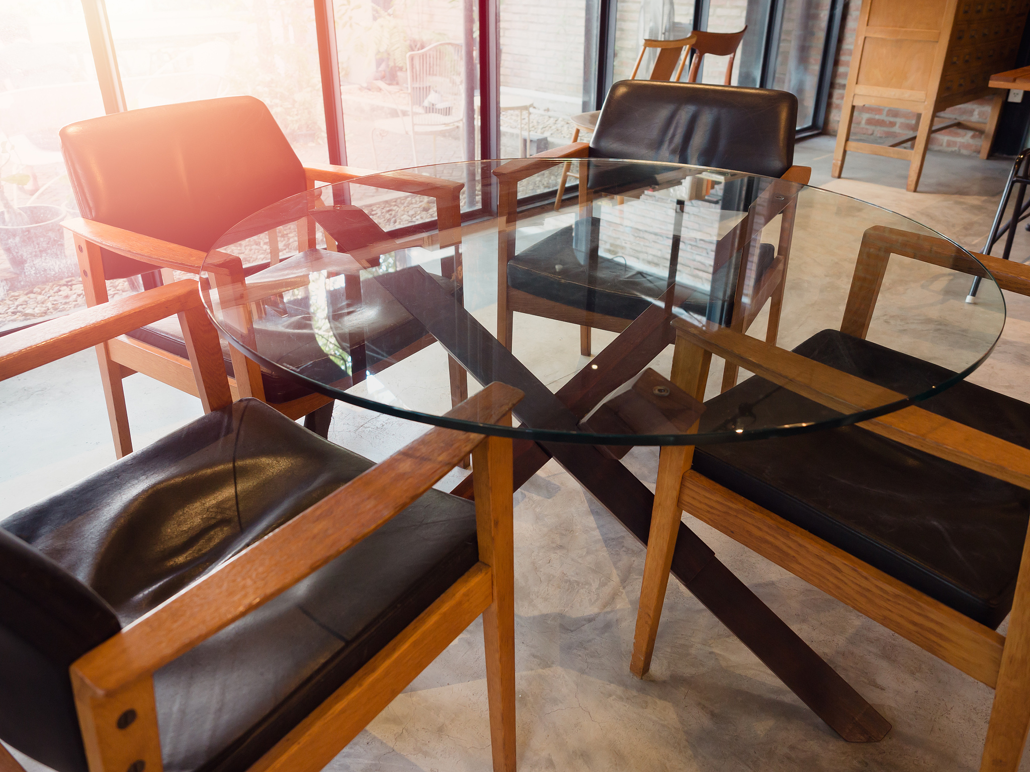 modern round glass table with four wooden chairs.