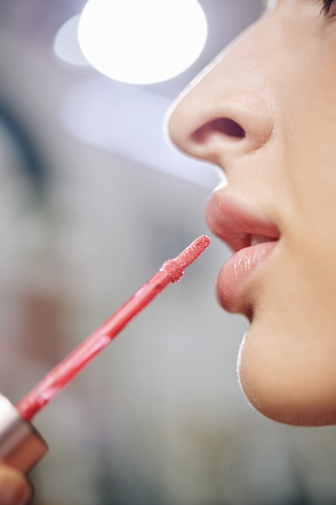 make-up artist applying light pink gloss