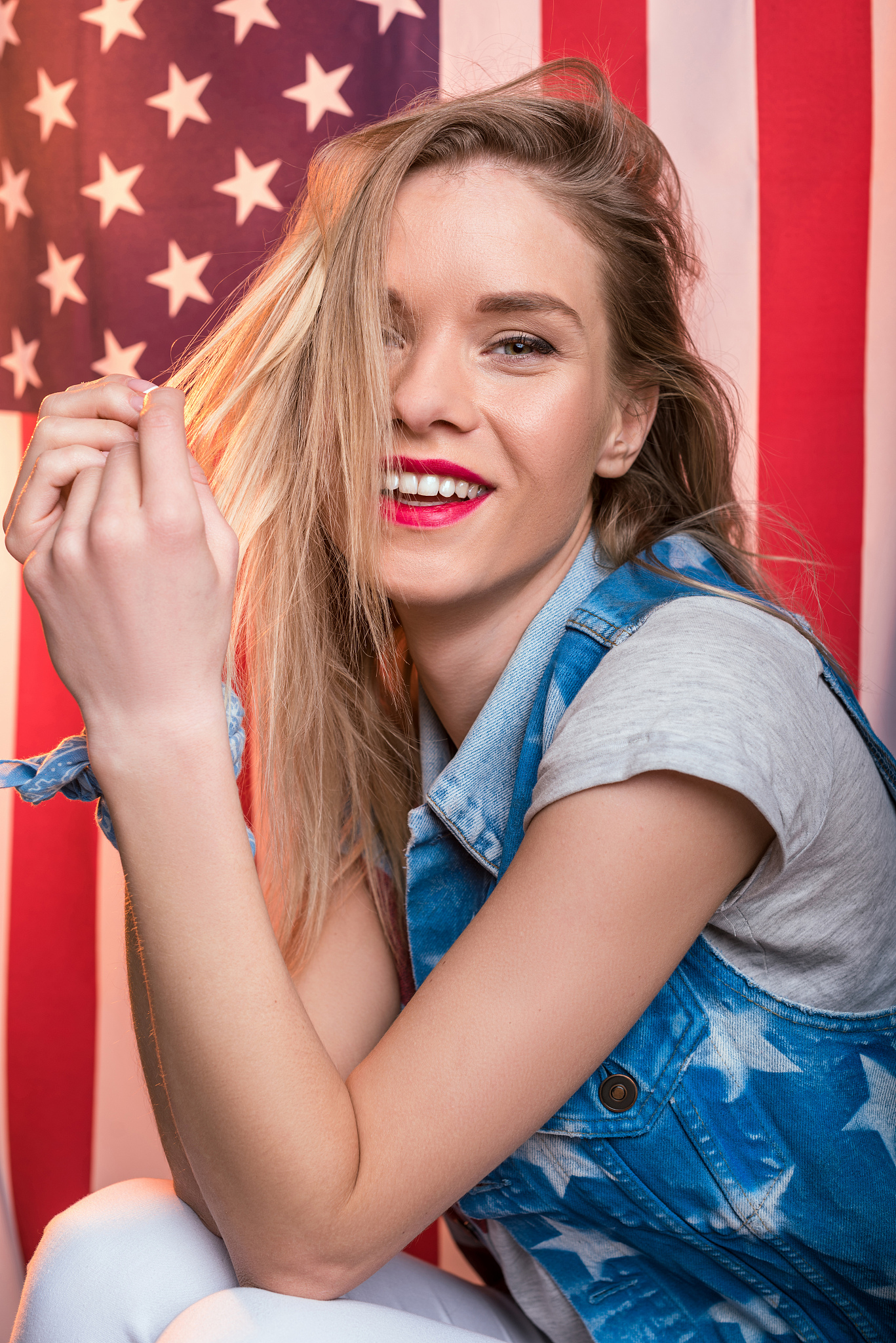 woman posing in front of usa flag, independence day of america