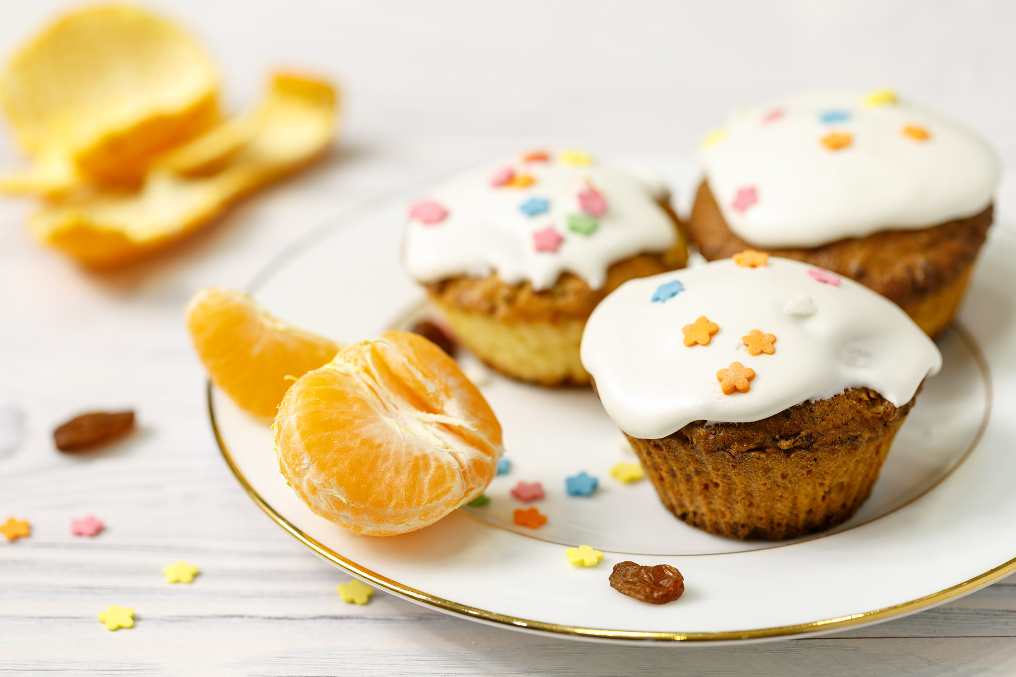a few appetizing muffins and slices of mandarin lie on a plate