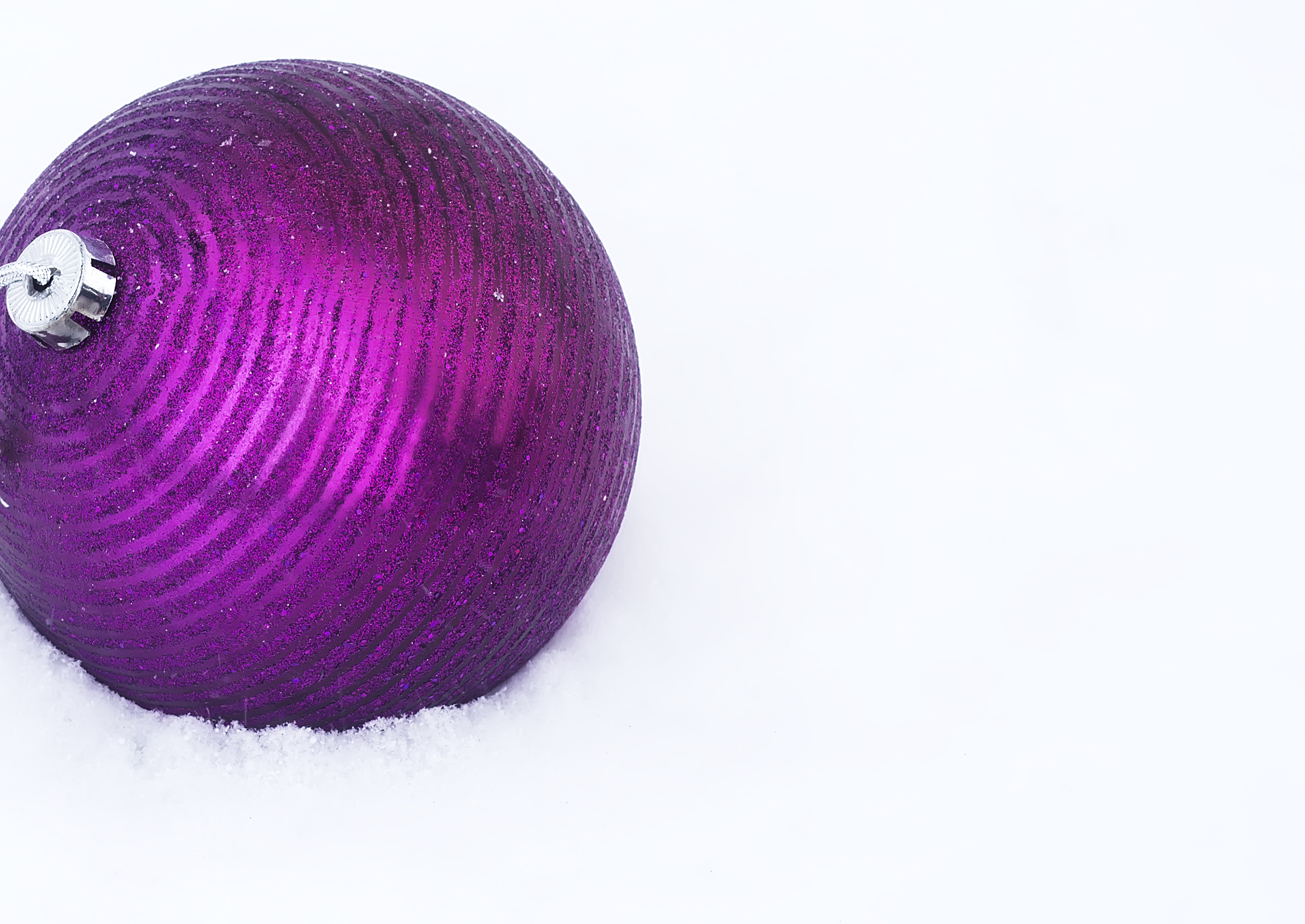 violet sphere a christmas tree decoration on snow covered branch