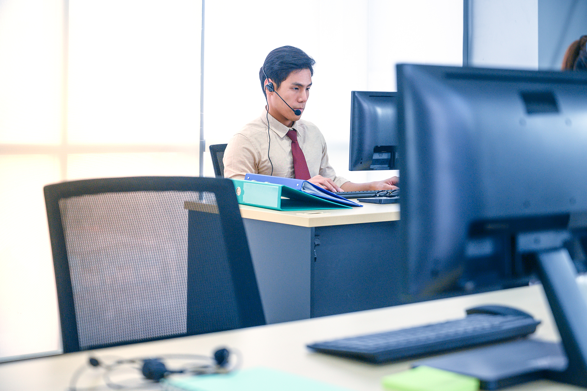 young customer service men agent with headsets and computer work