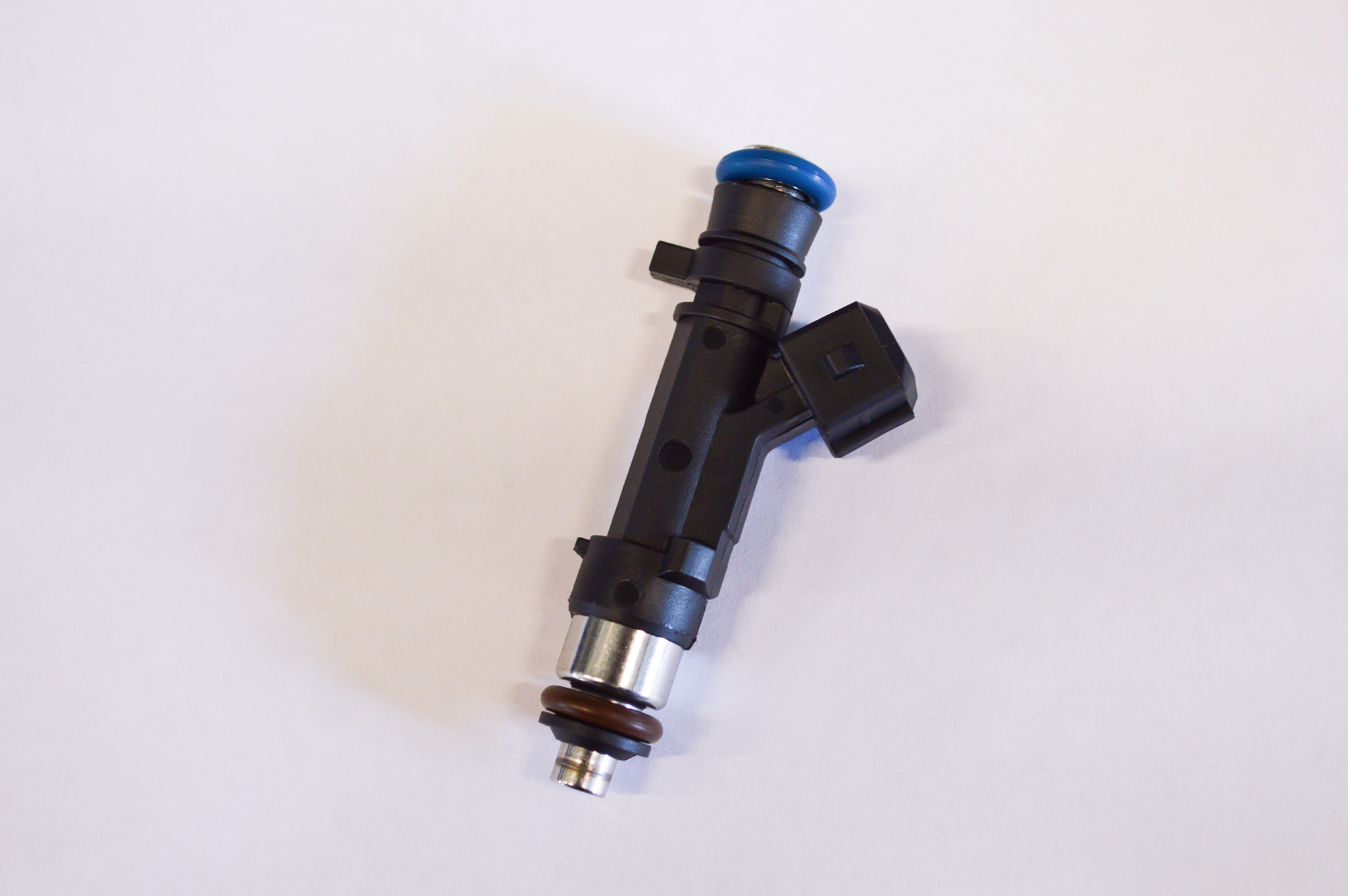 black petrol injector on a light grey background
