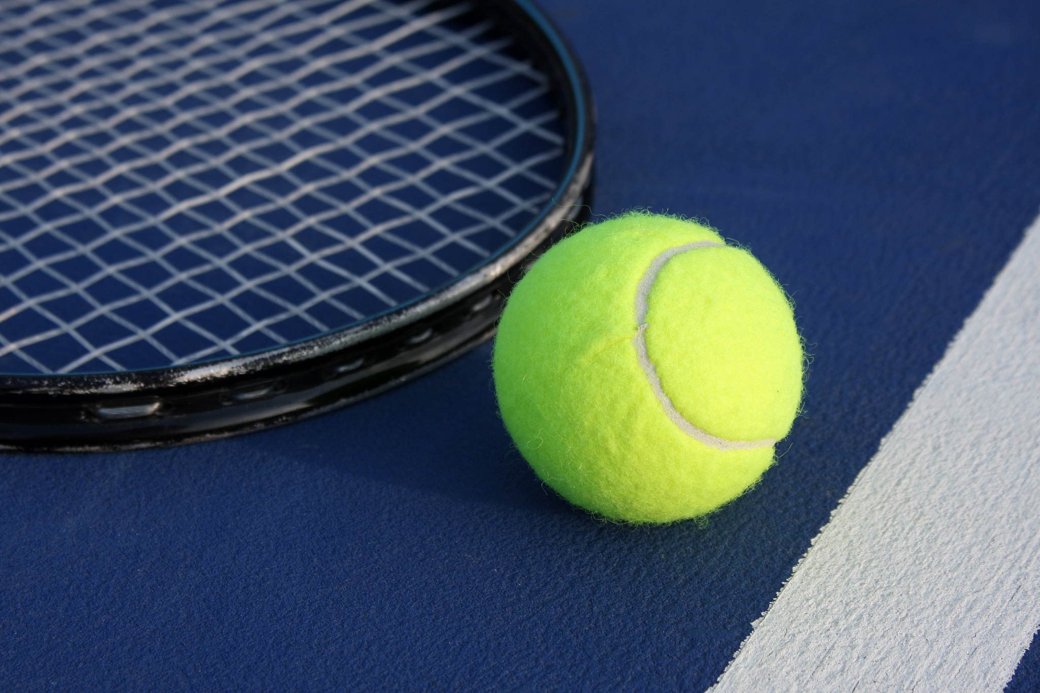 tennis ball with racquet on a modern court