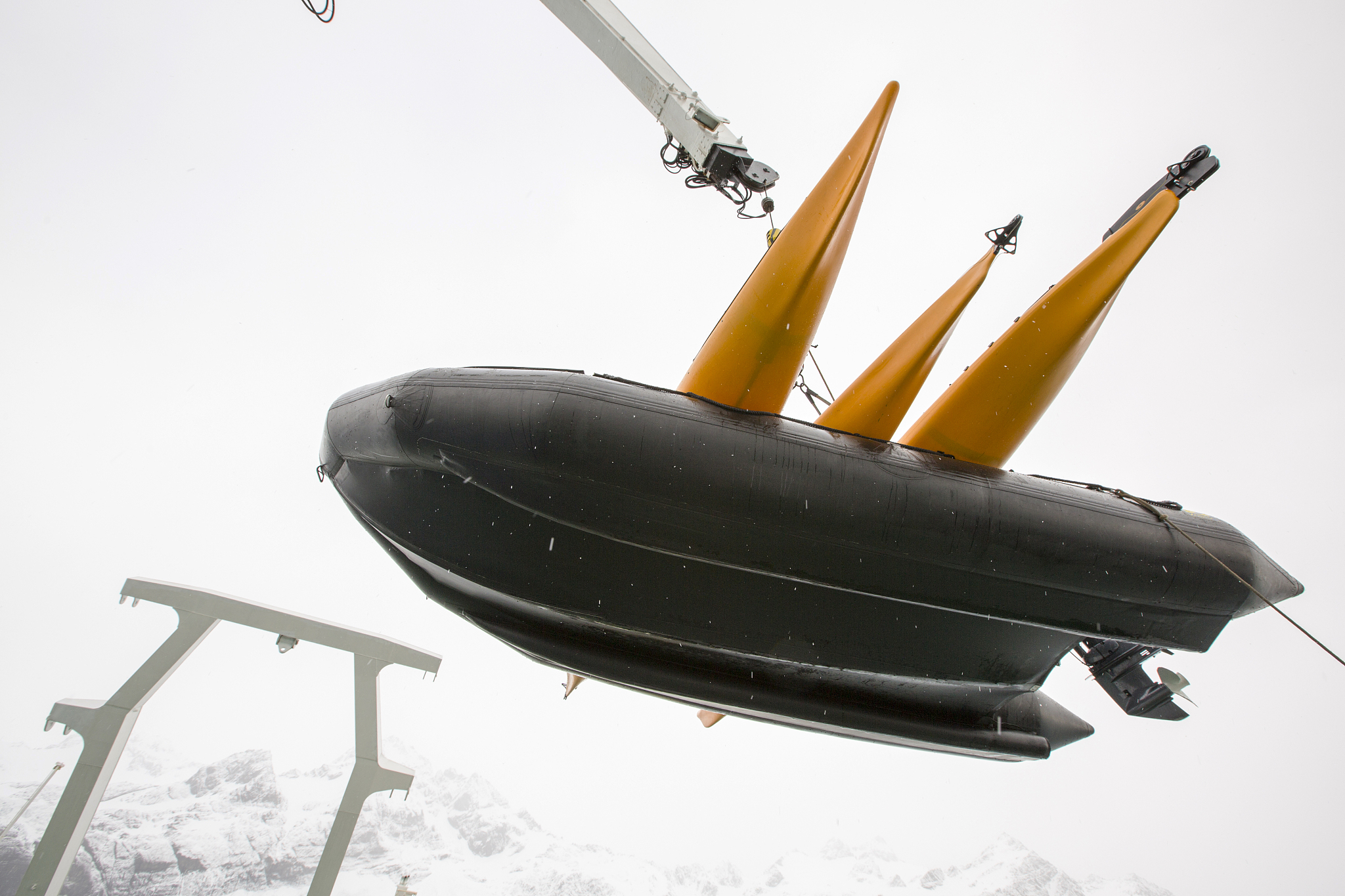 zodiaks and sea kayaks being lifted off the deck of an expeditio