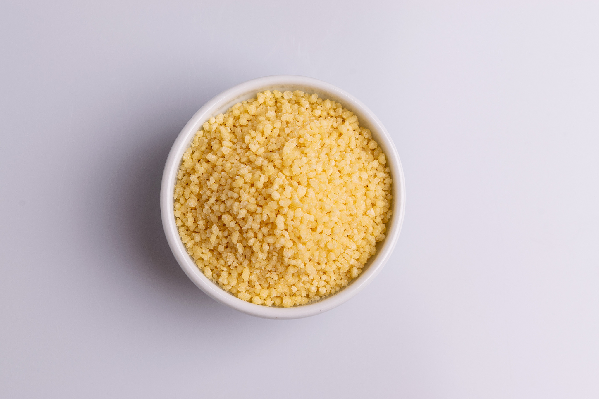 dry couscous isolated on white background, soft light, copy spac
