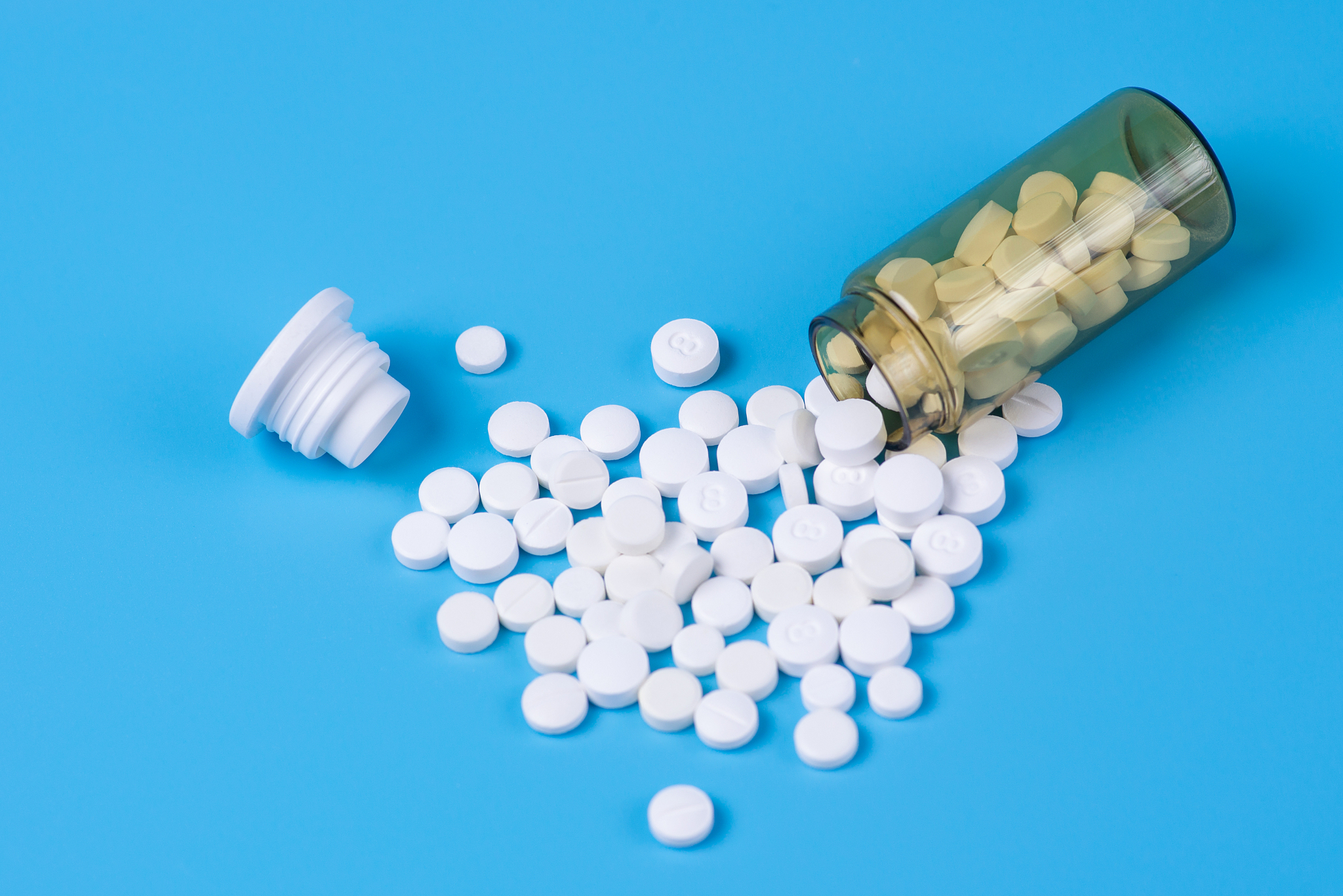 assorted pharmaceutical medicine pills, white pills in the glass