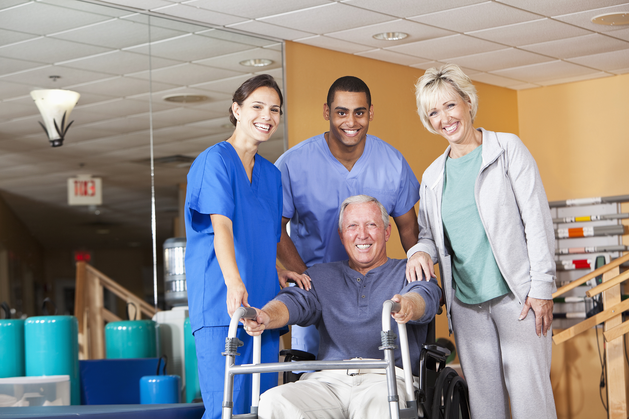 physical therapists with patient and spouse