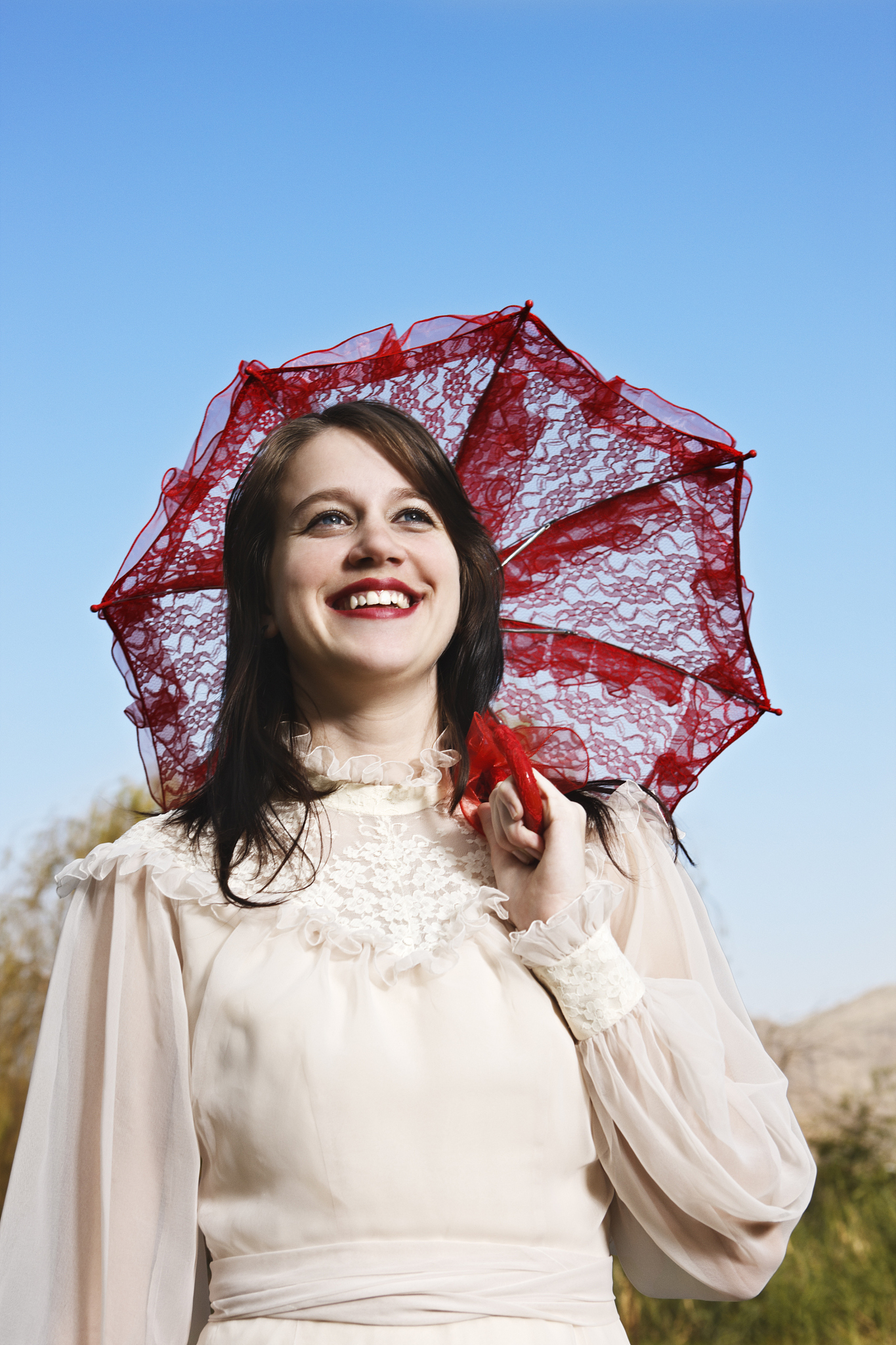 young woman in edwardian dress with parasol, smiling