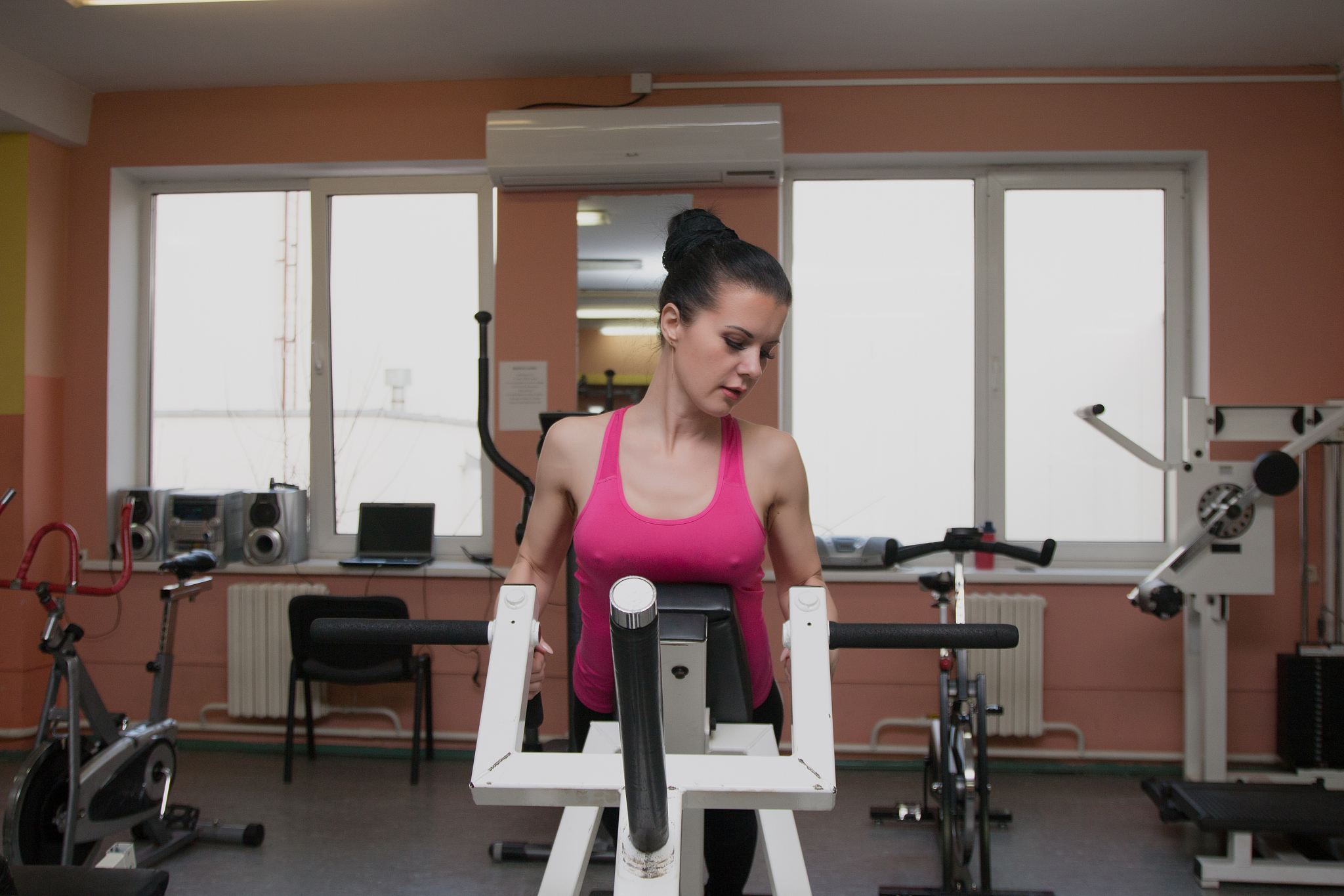 beautiful girl is exercising in the fitness club on the simulato