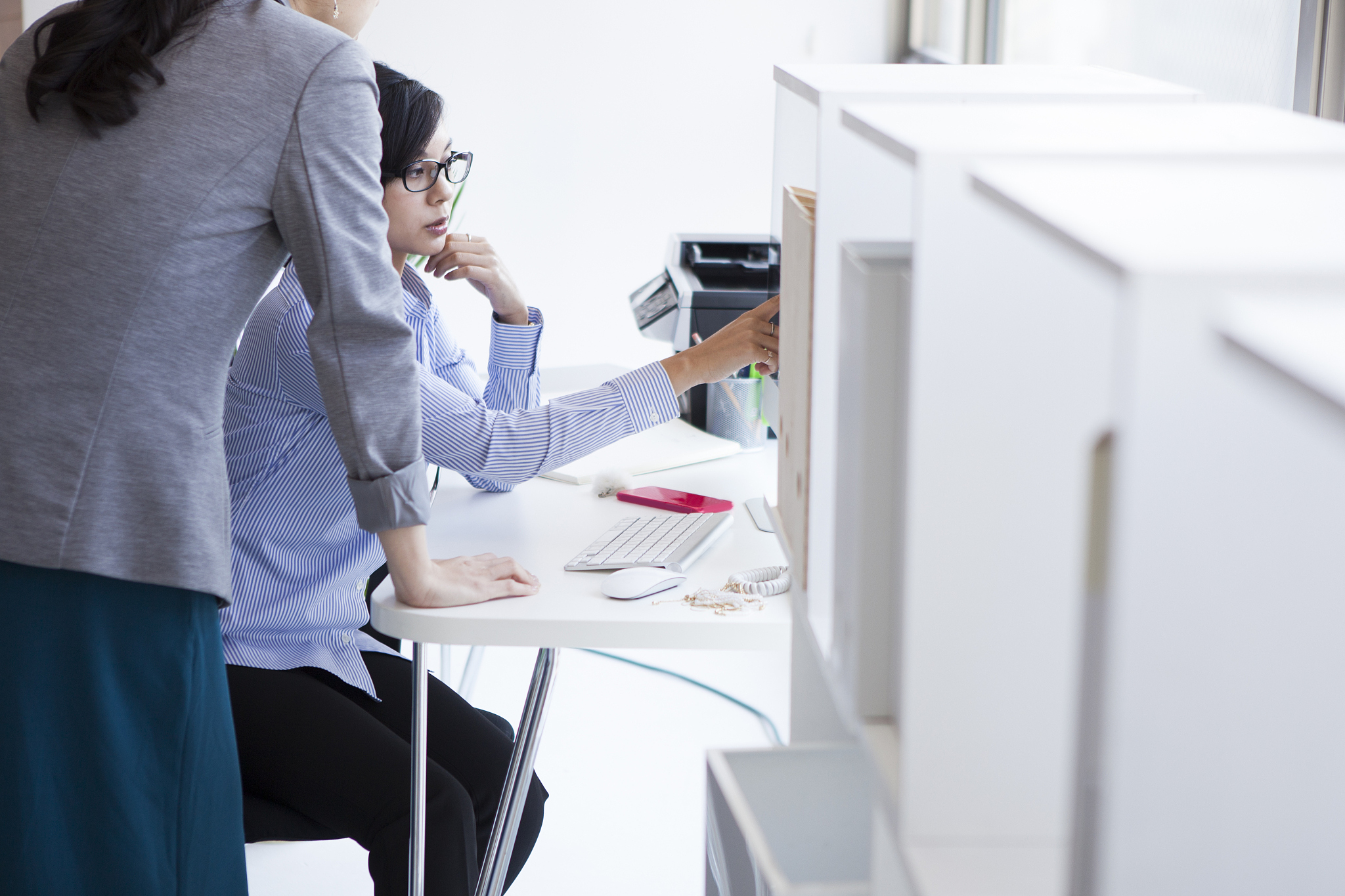 women who are asked to look at document to boss