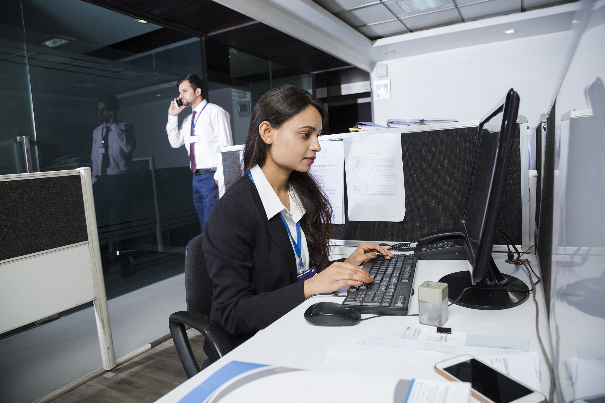 businesswoman in her office at night working late - stock image