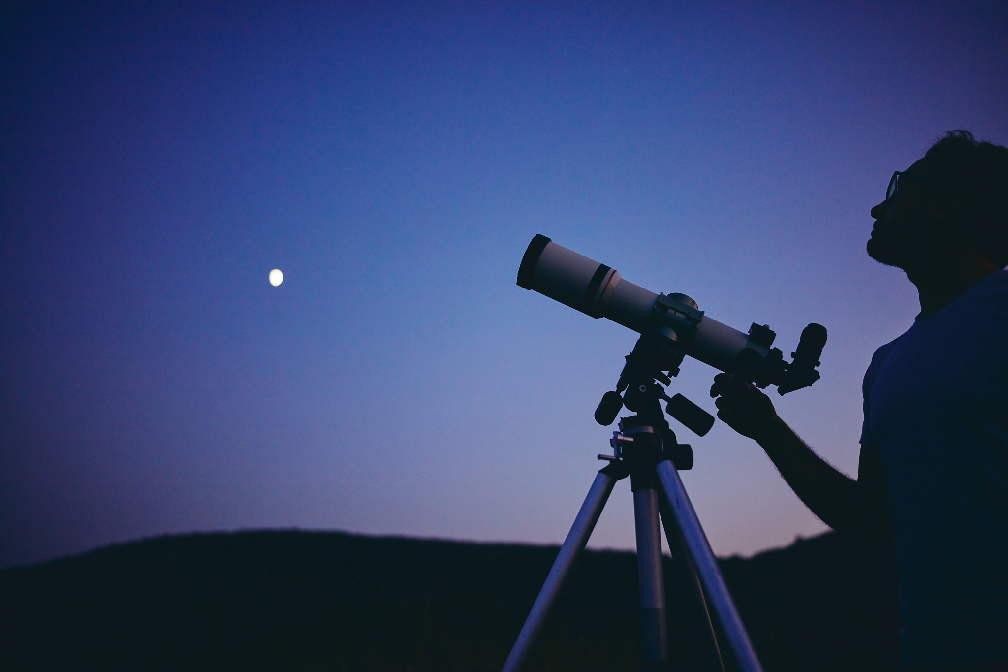 astronomer with a telescope watching at the stars and moon. my a