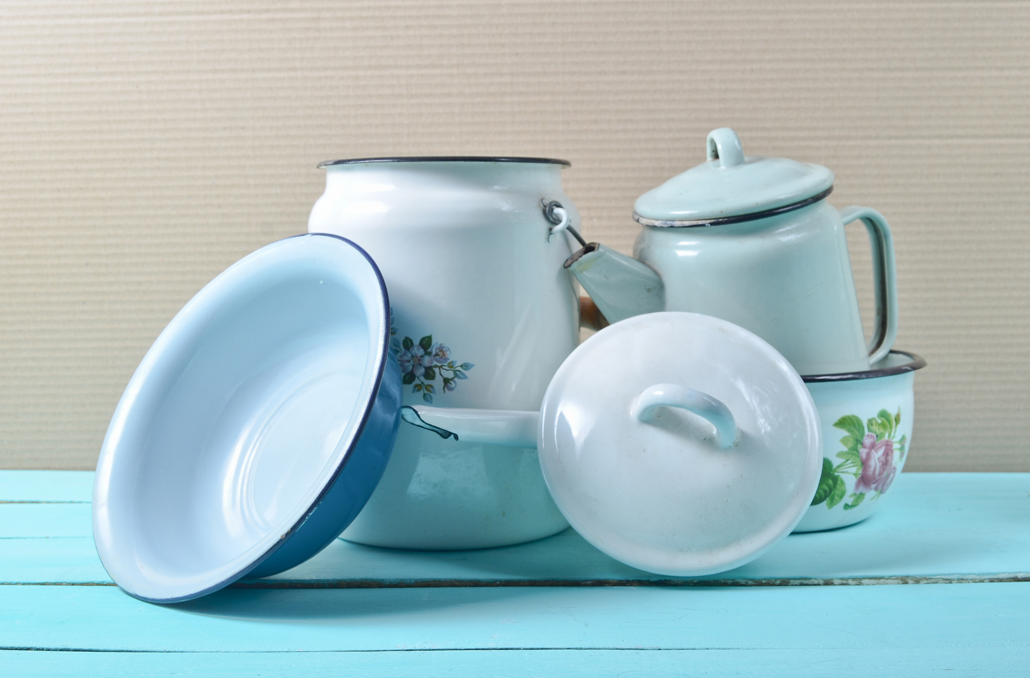 lot of enameled dishes on a blue table. retro style cookware'