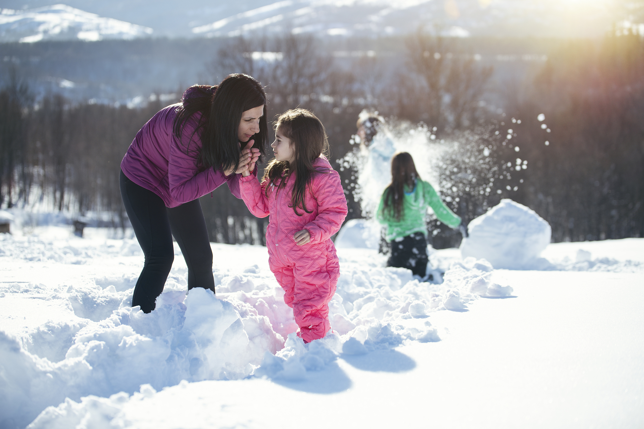 family is playing outside at the snow