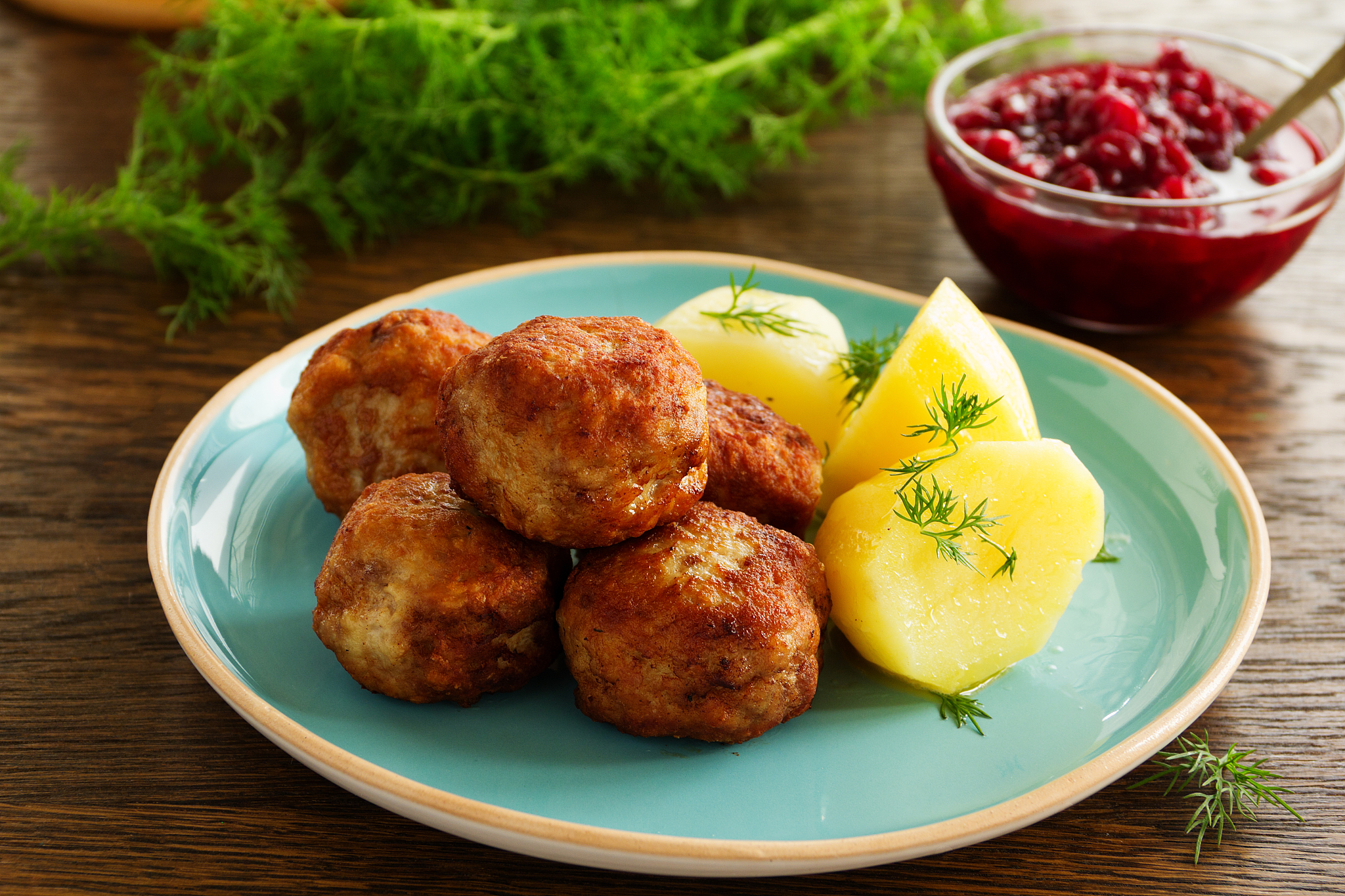 hot meatballs with boiled potatoes and cranberry sauce ..