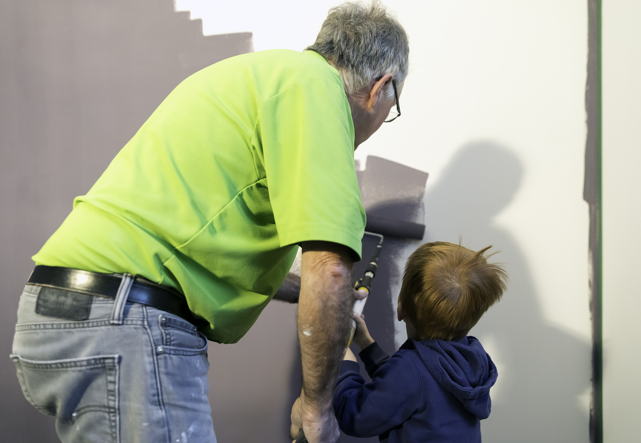 grandfather painting new house with grandson