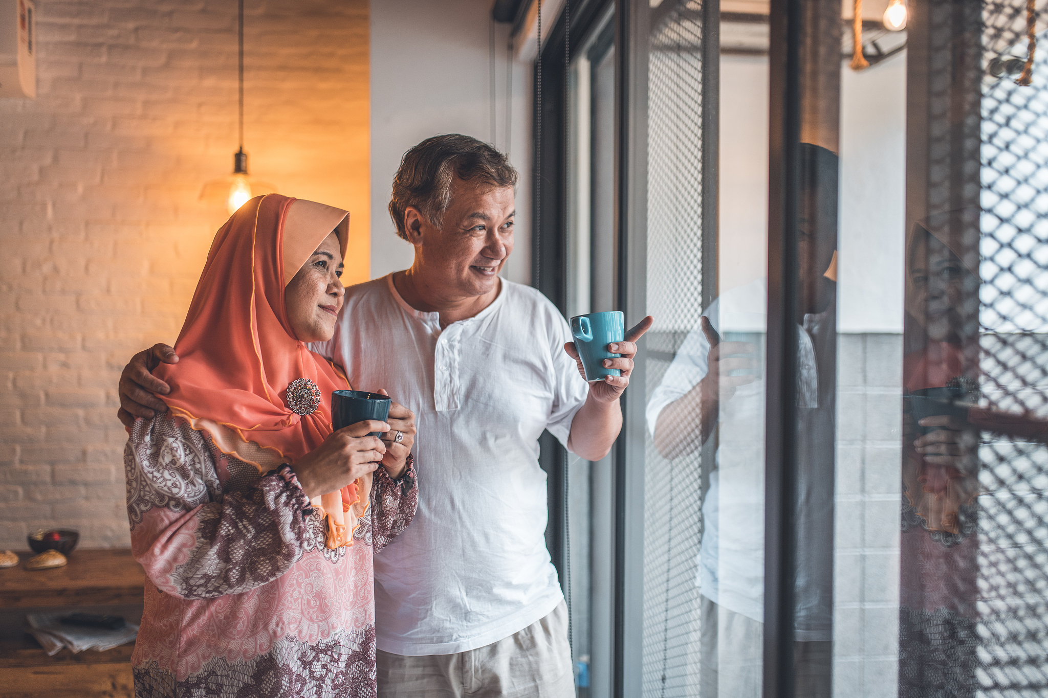 senior couple having coffee by window at home