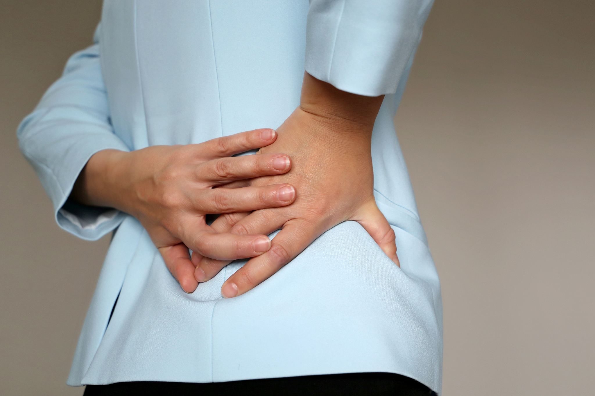 pain in side, woman in office suit suffering from backache