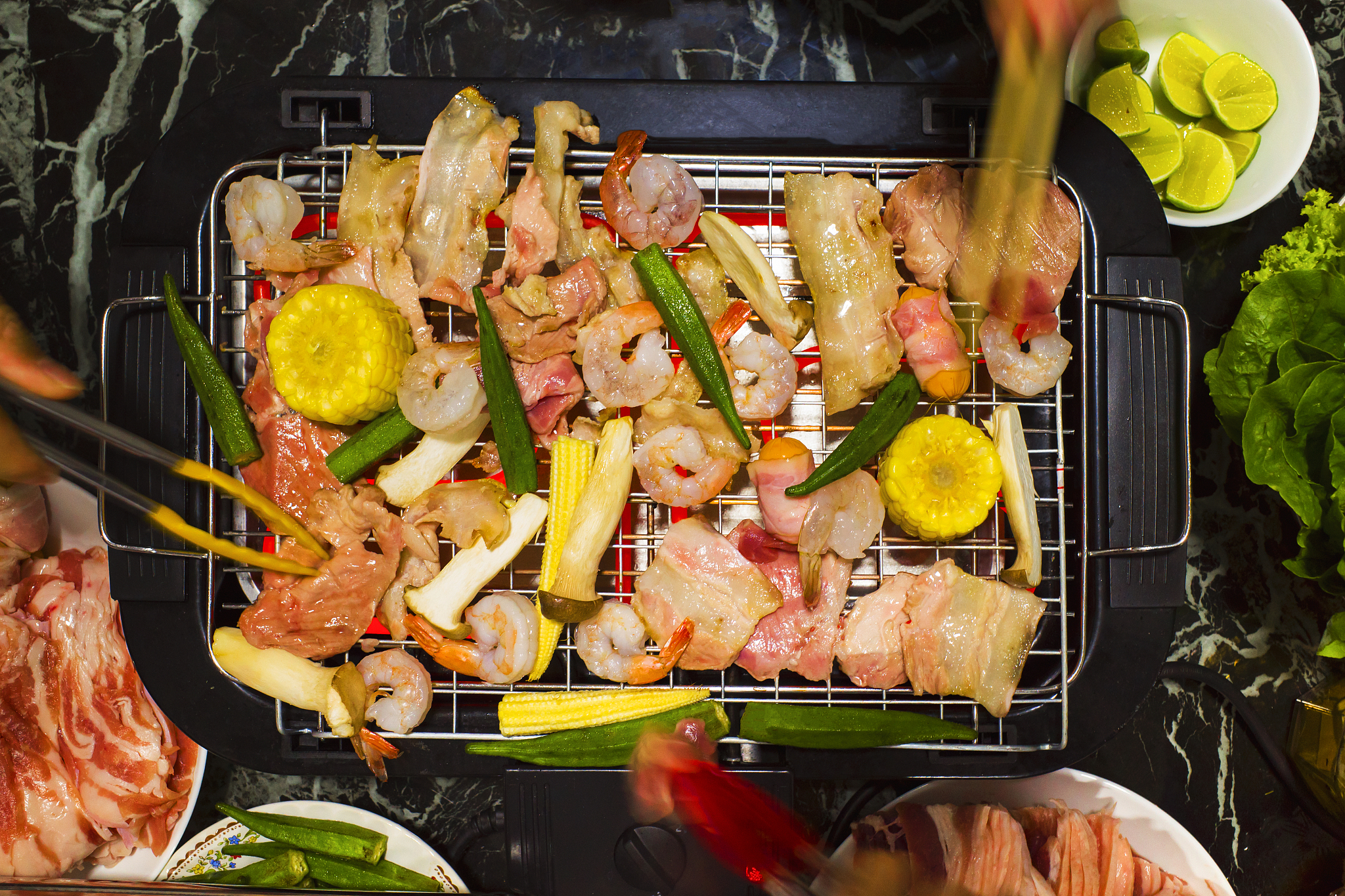 cropped hands of people preparing food on barbecue grill