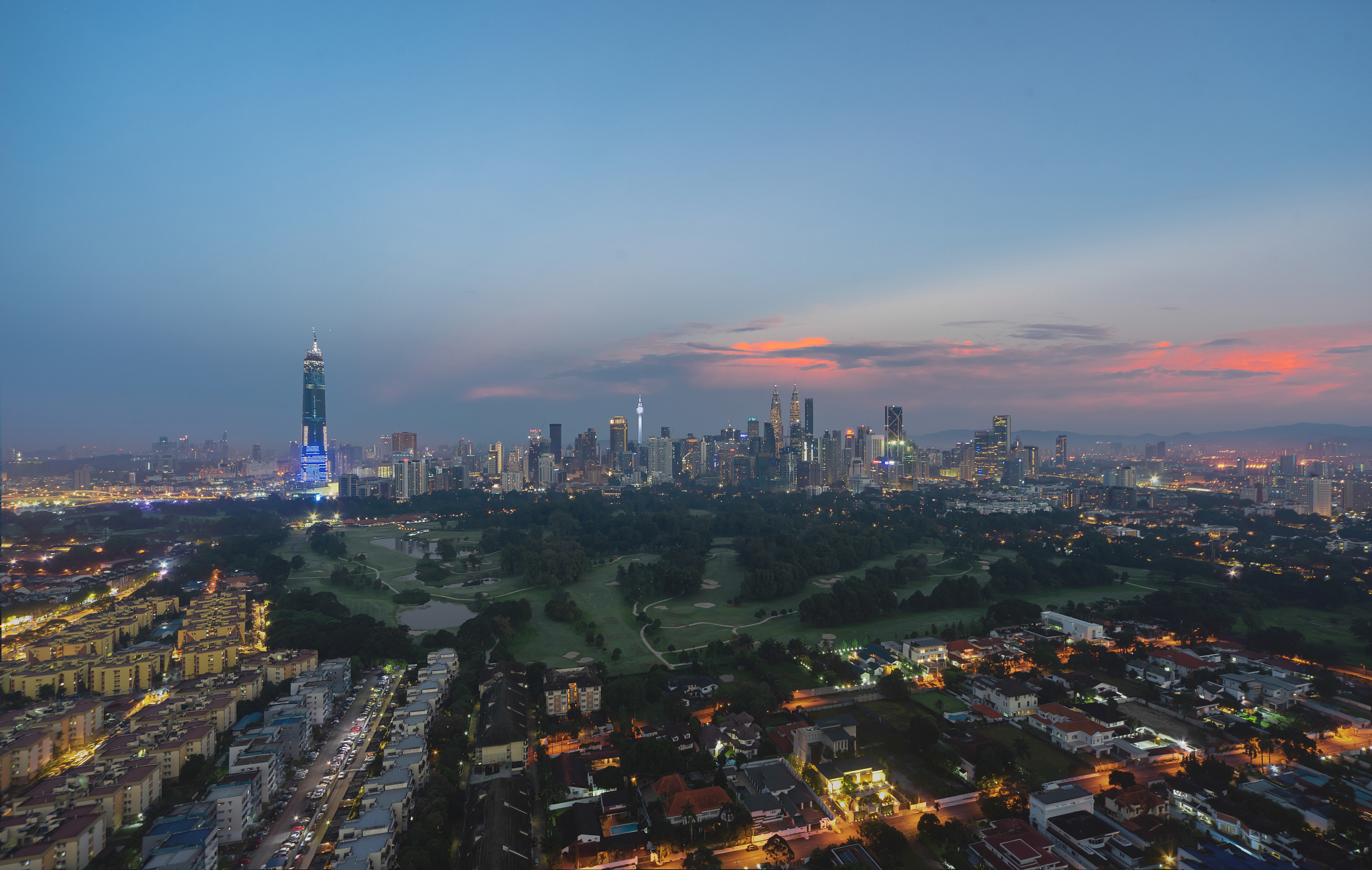 aerial view of illuminated buildings in city against sky