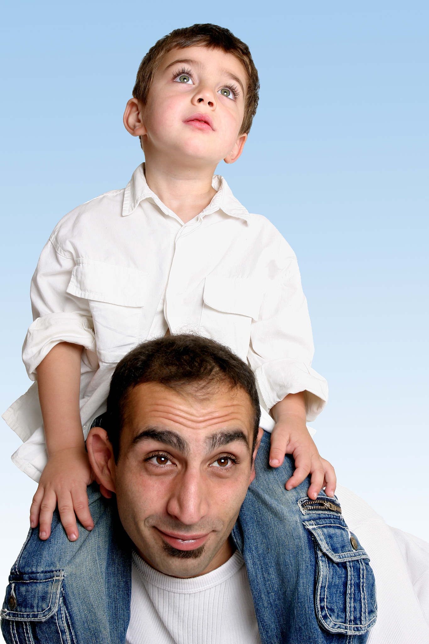 child sitting on father's shoulders