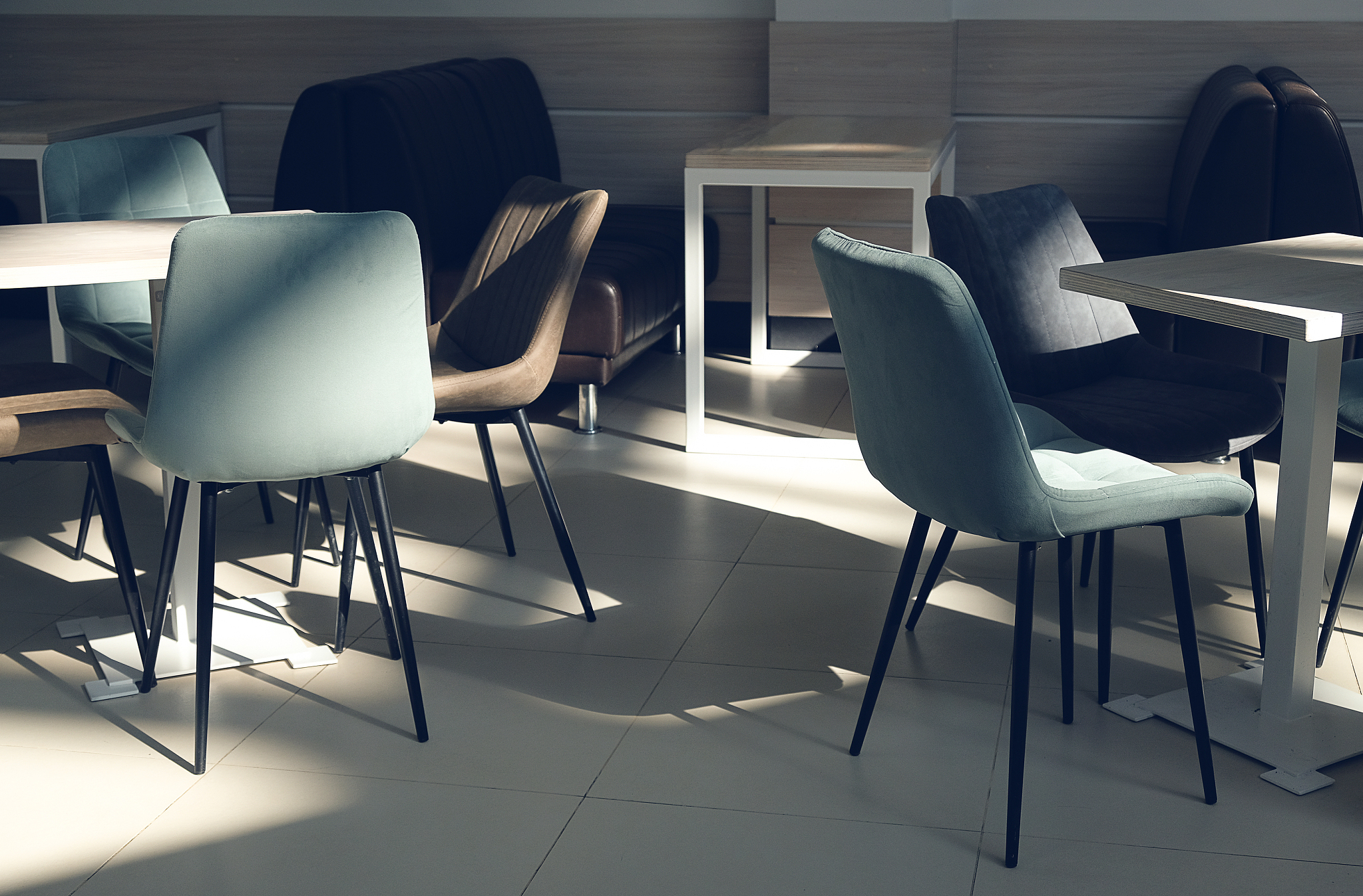 an empty room of a cafe, office with wooden tables and velour ar