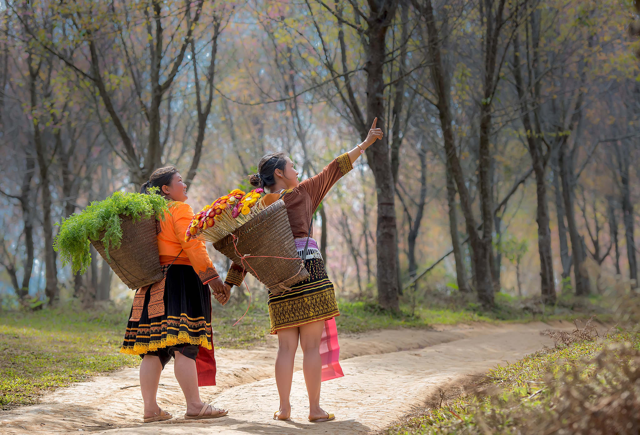 rear view of female friends holding hands while standing on foot