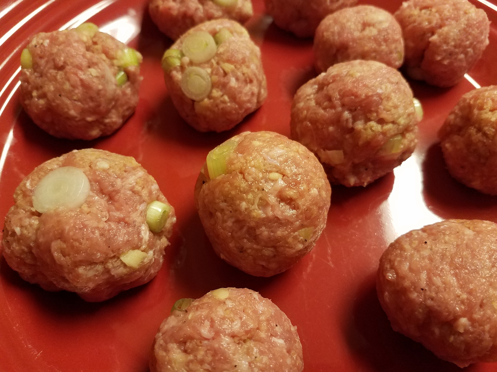 pork and onion meatballs on red plate