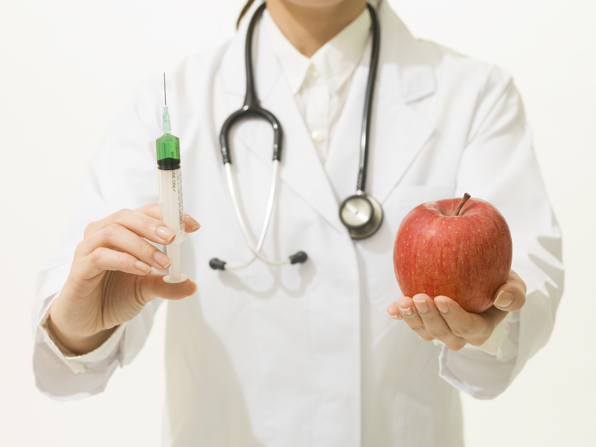 female doctor injecting apple