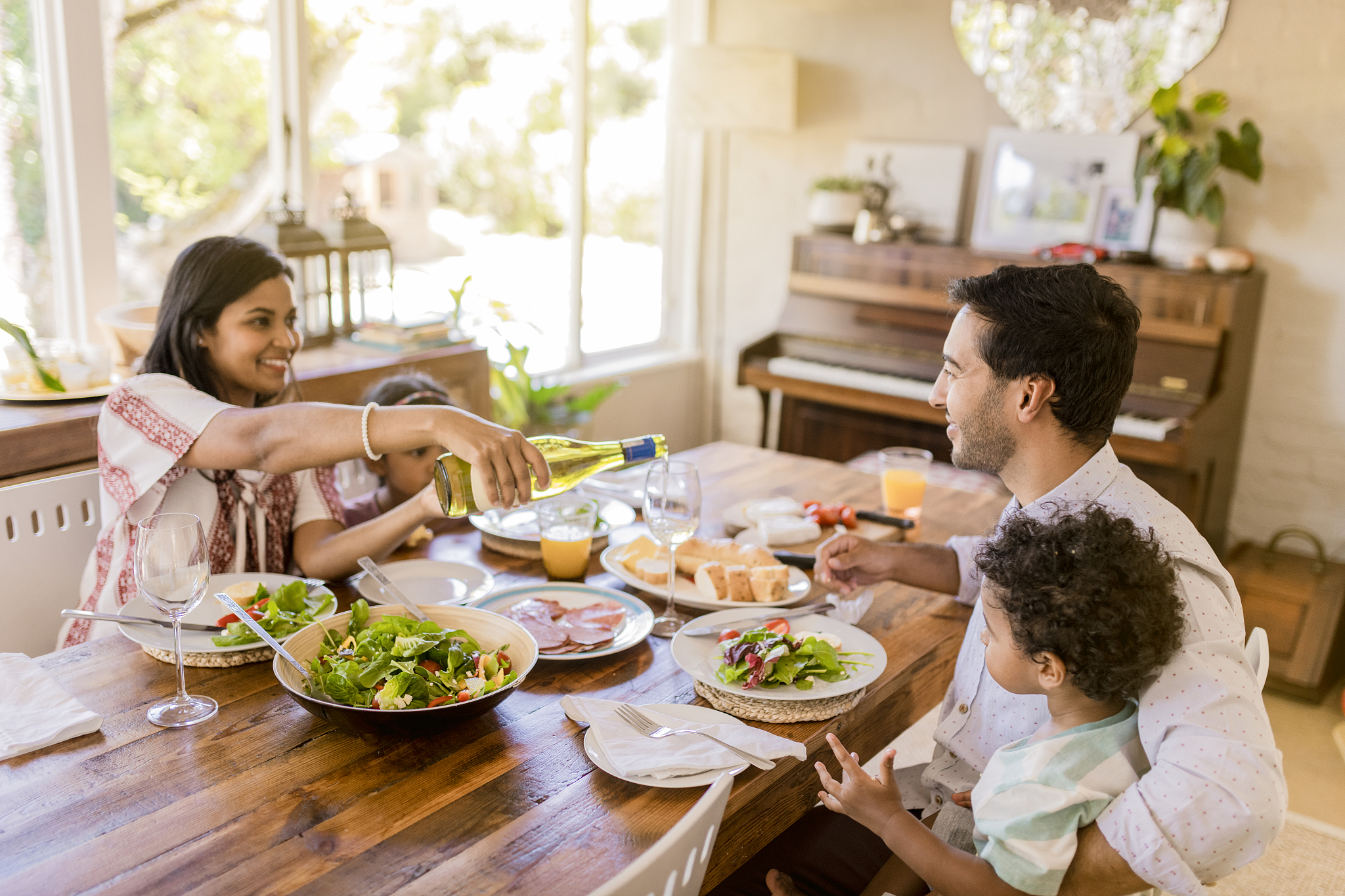 woman sitting with family pouring wine in glass