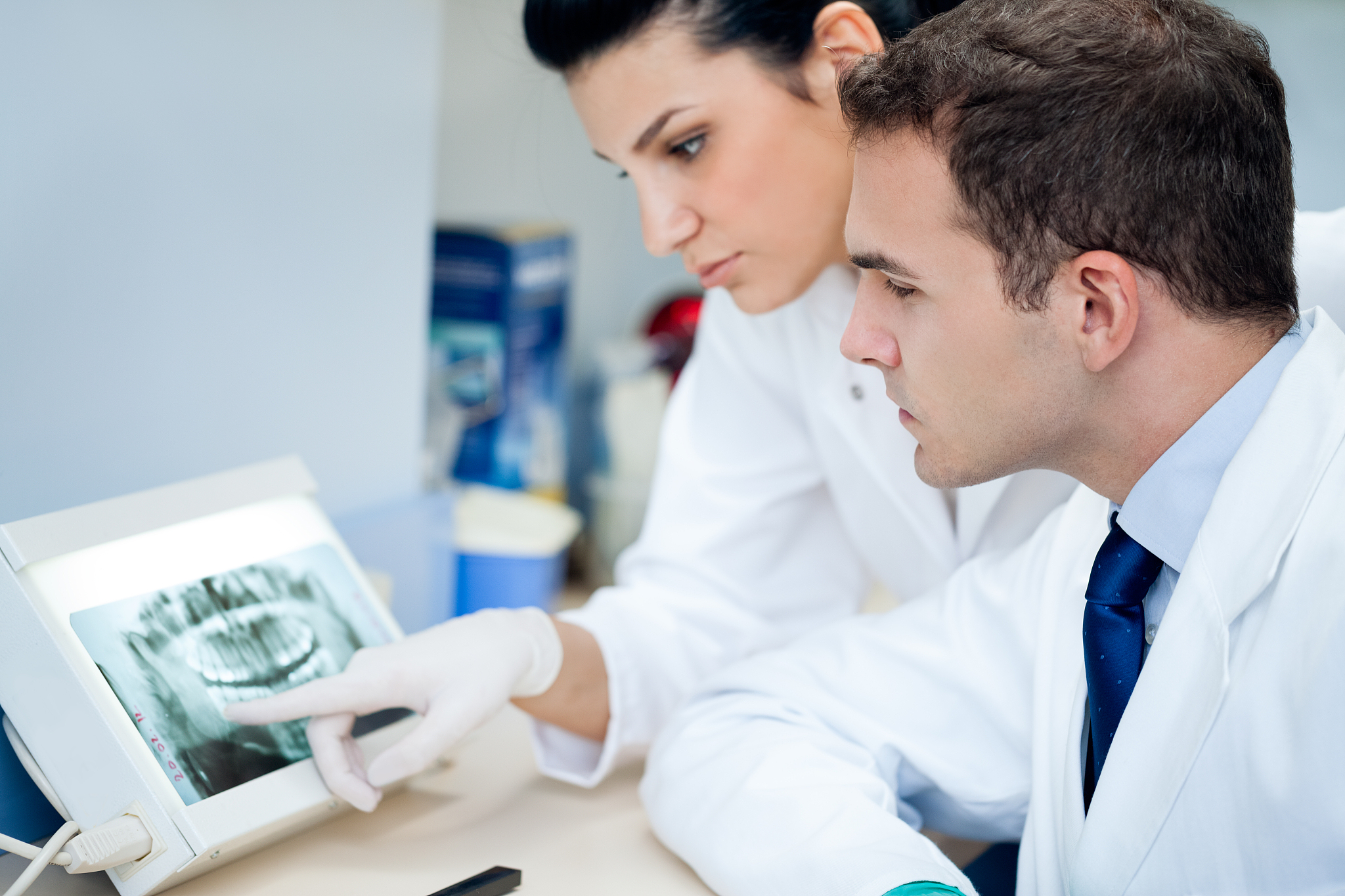 two dentists examining a dental x-ray