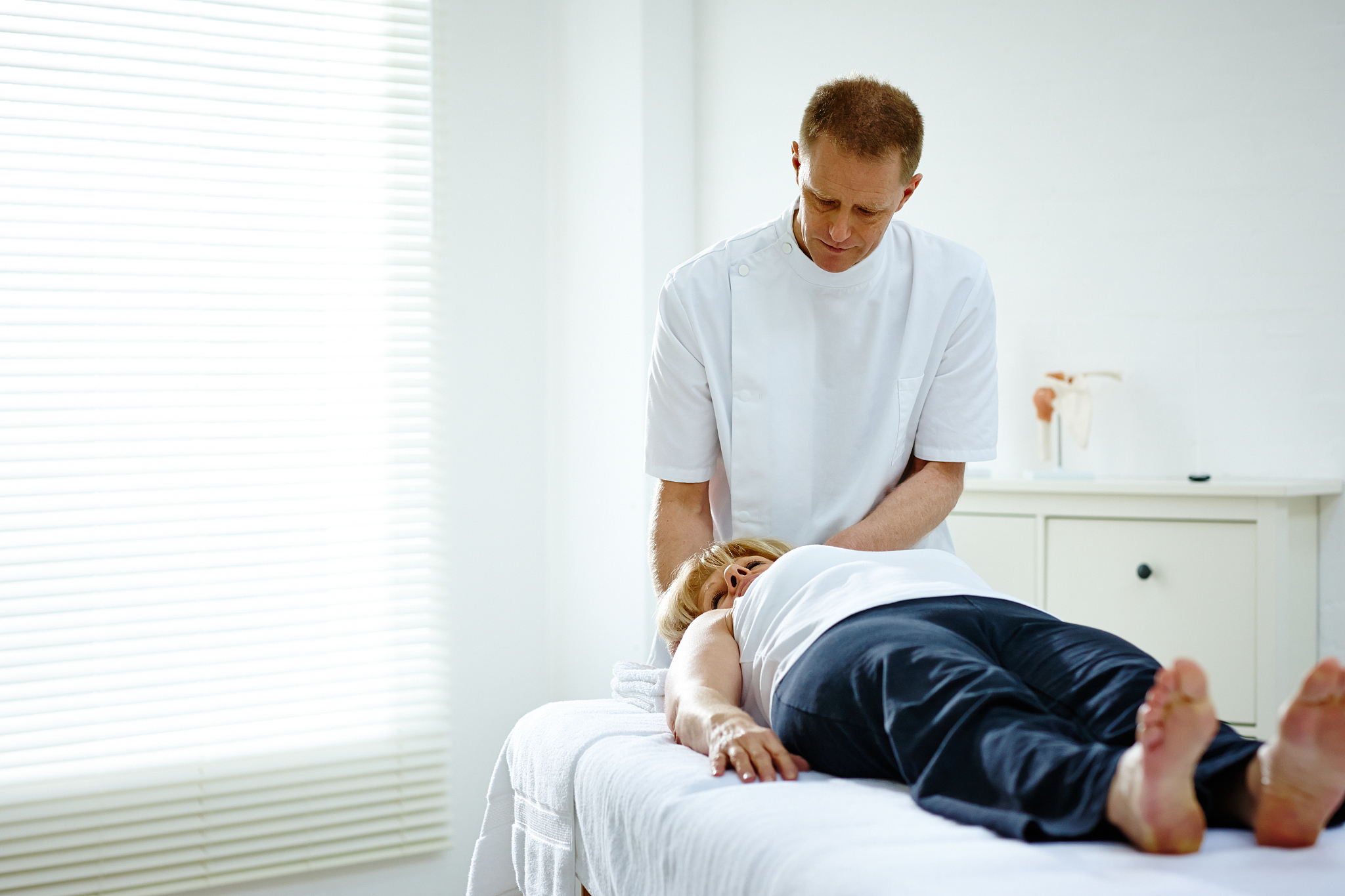 male physical therapist treating female patient