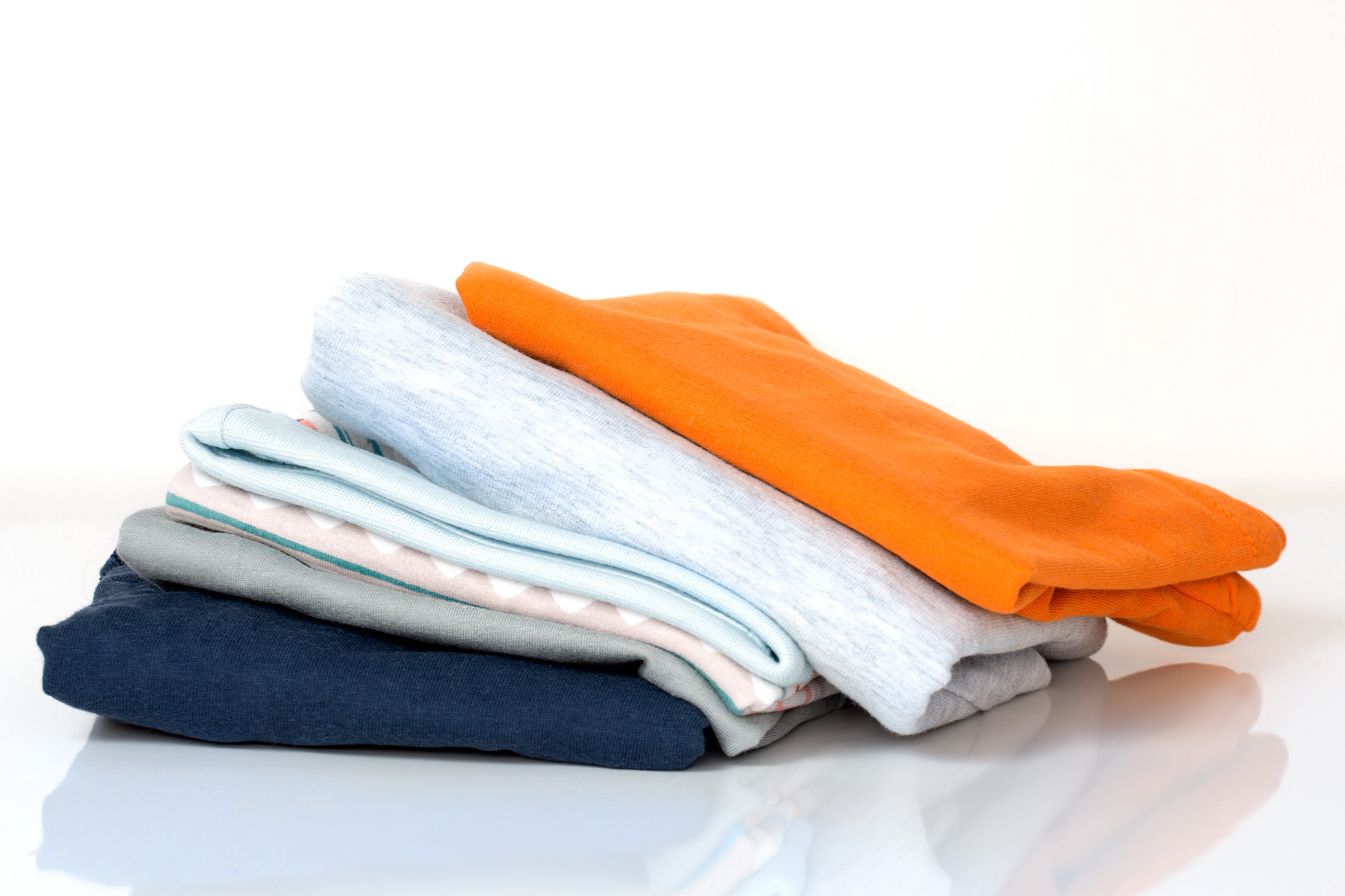 stack pile folded cotton clothes on white.