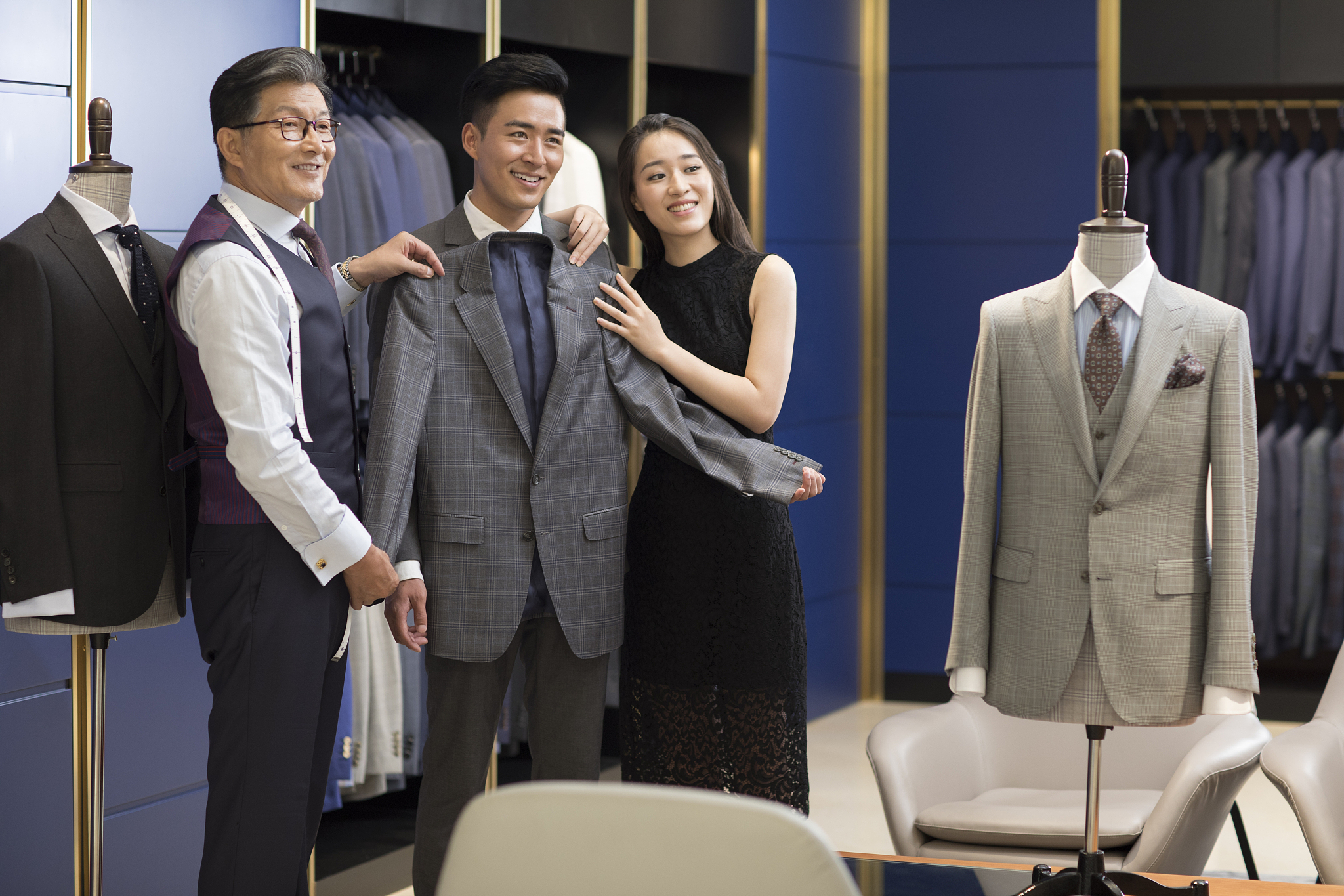 年轻情侣在服装店挑选西装