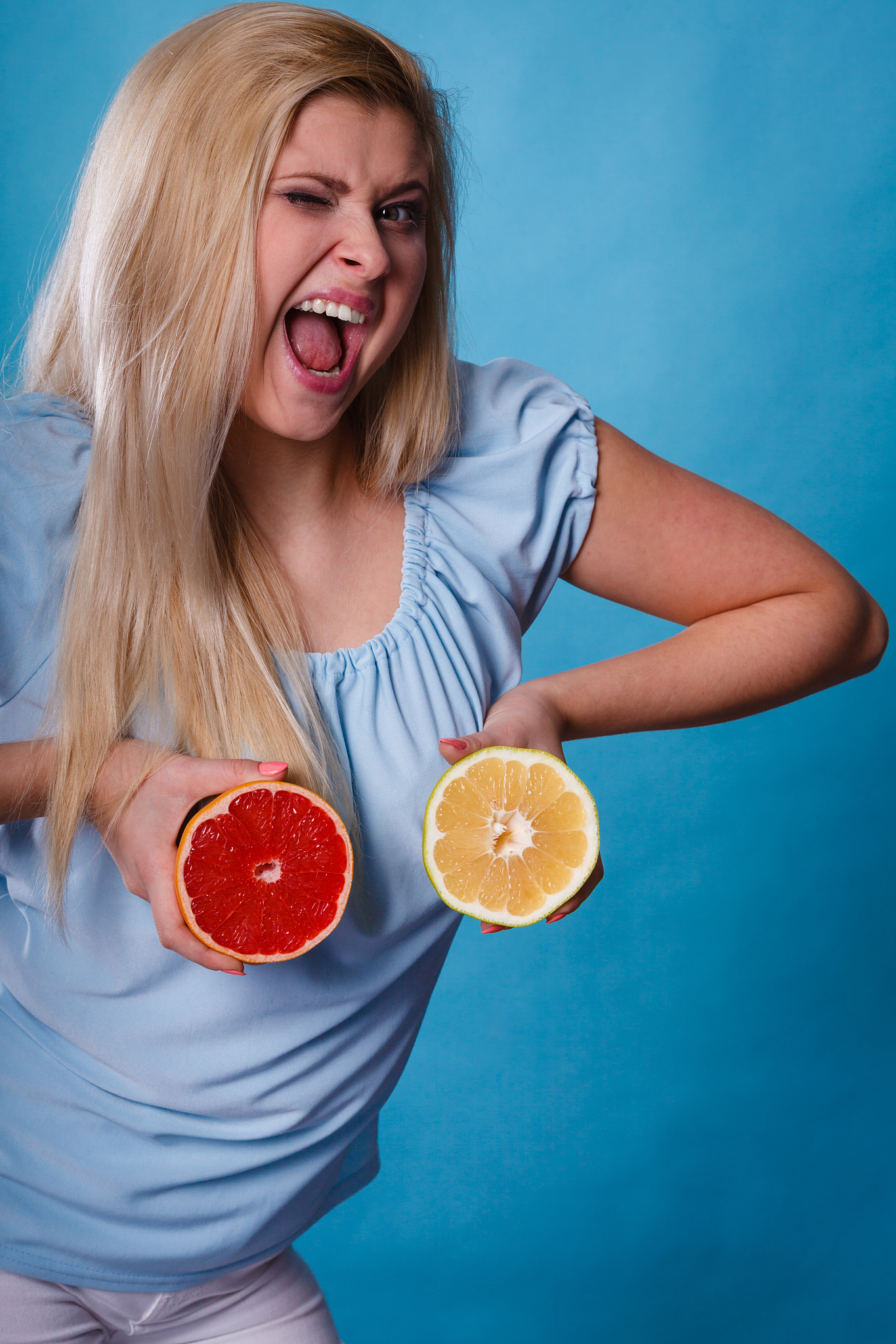 woman holding red and green grapefruit