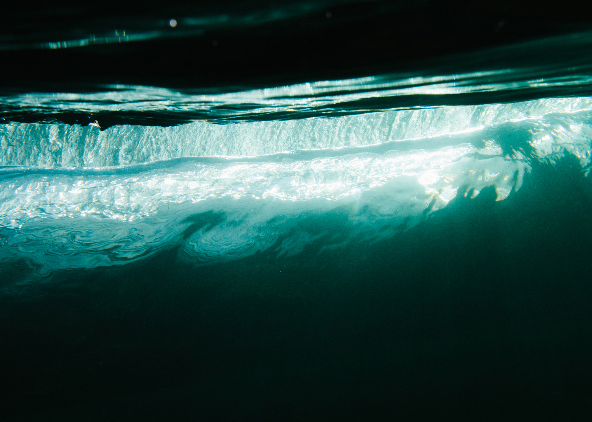 cool light reflecting through a small wave underwater in ireland