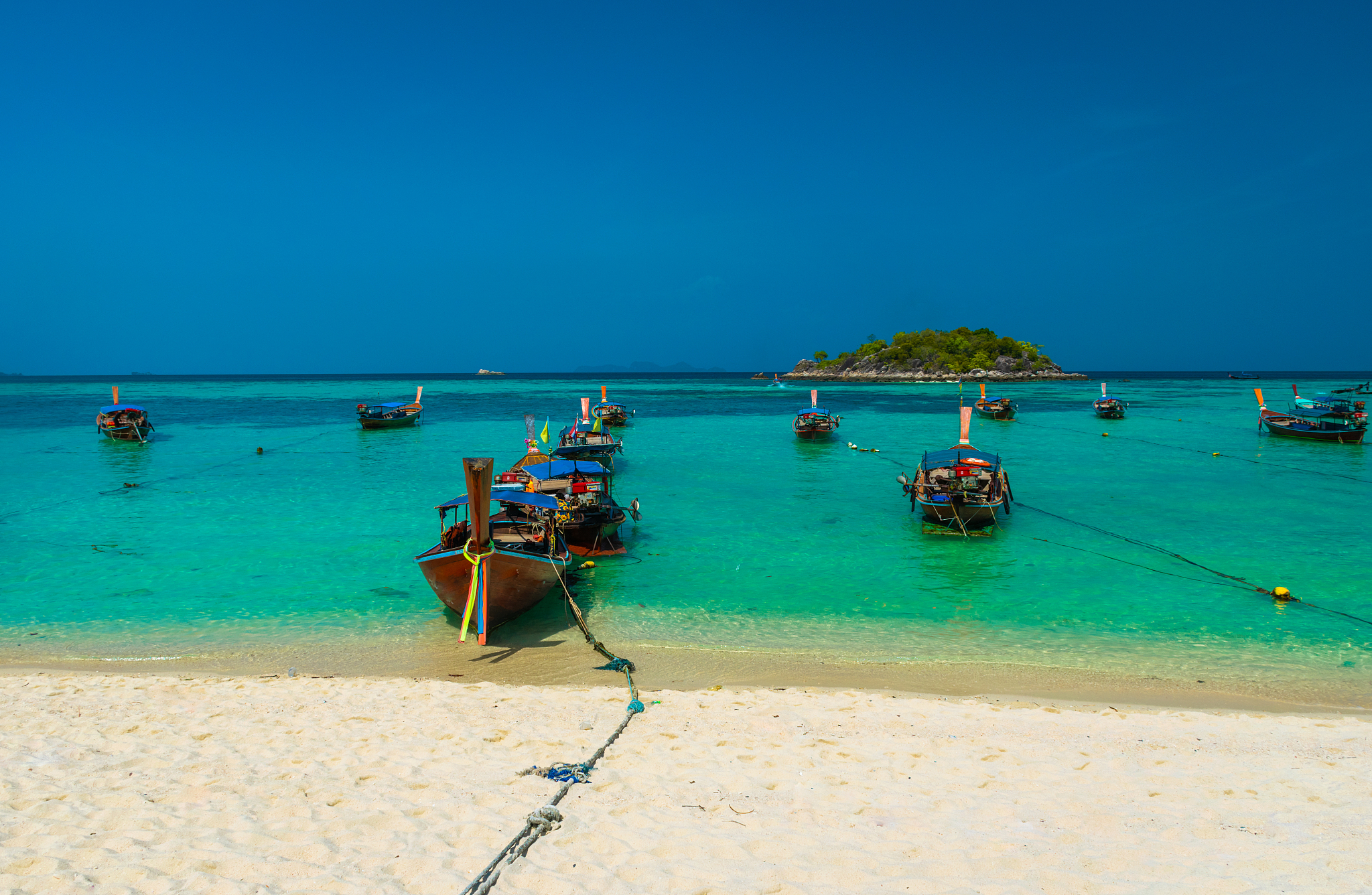 beautiful longtail boats moored on beach against sky at koh lipe