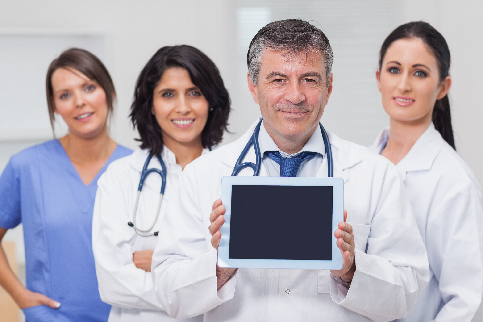 doctor showing tablet pc with his team