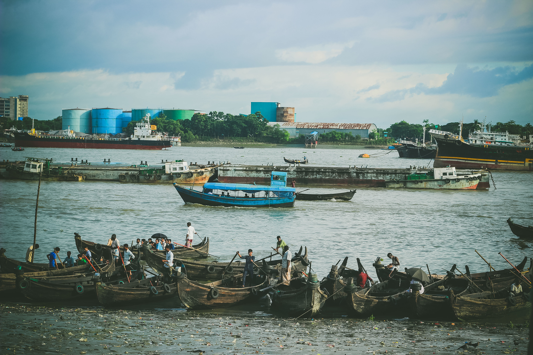 people standing in boats moored on river